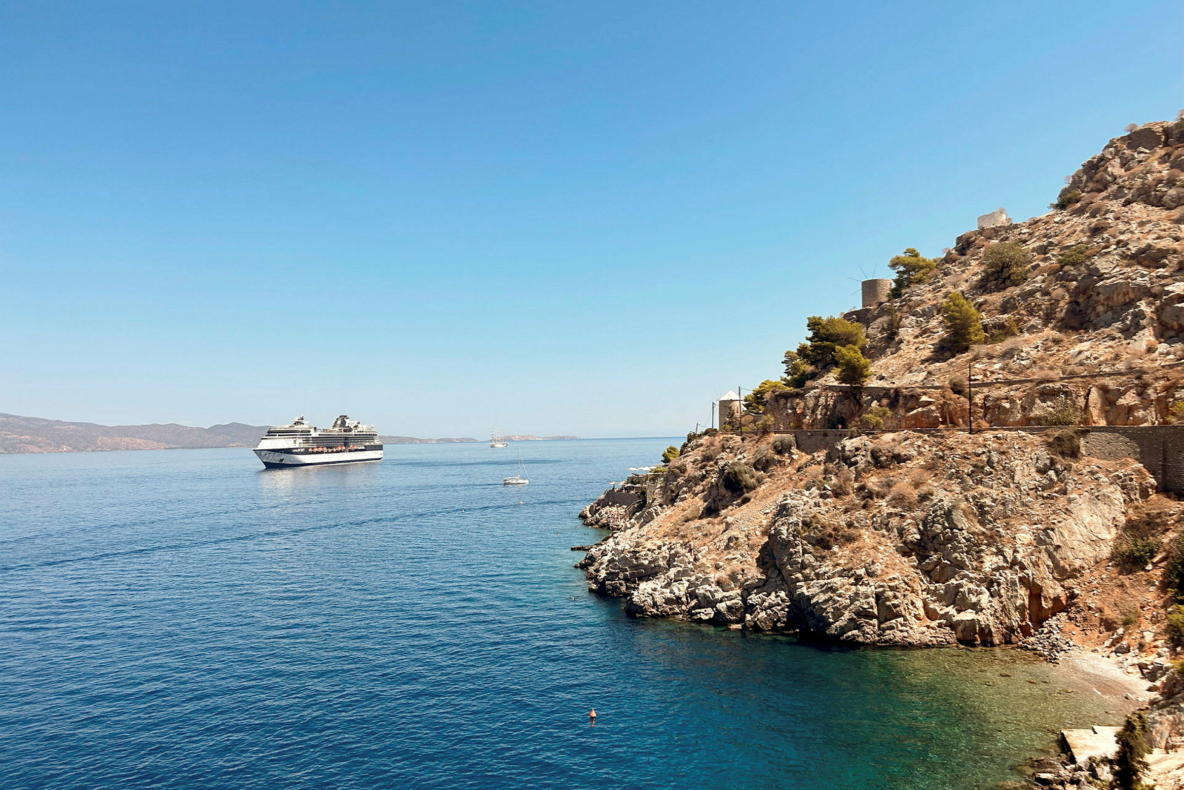 Et cruiseskip på havet nær en klippe. (AI-generert tekst)