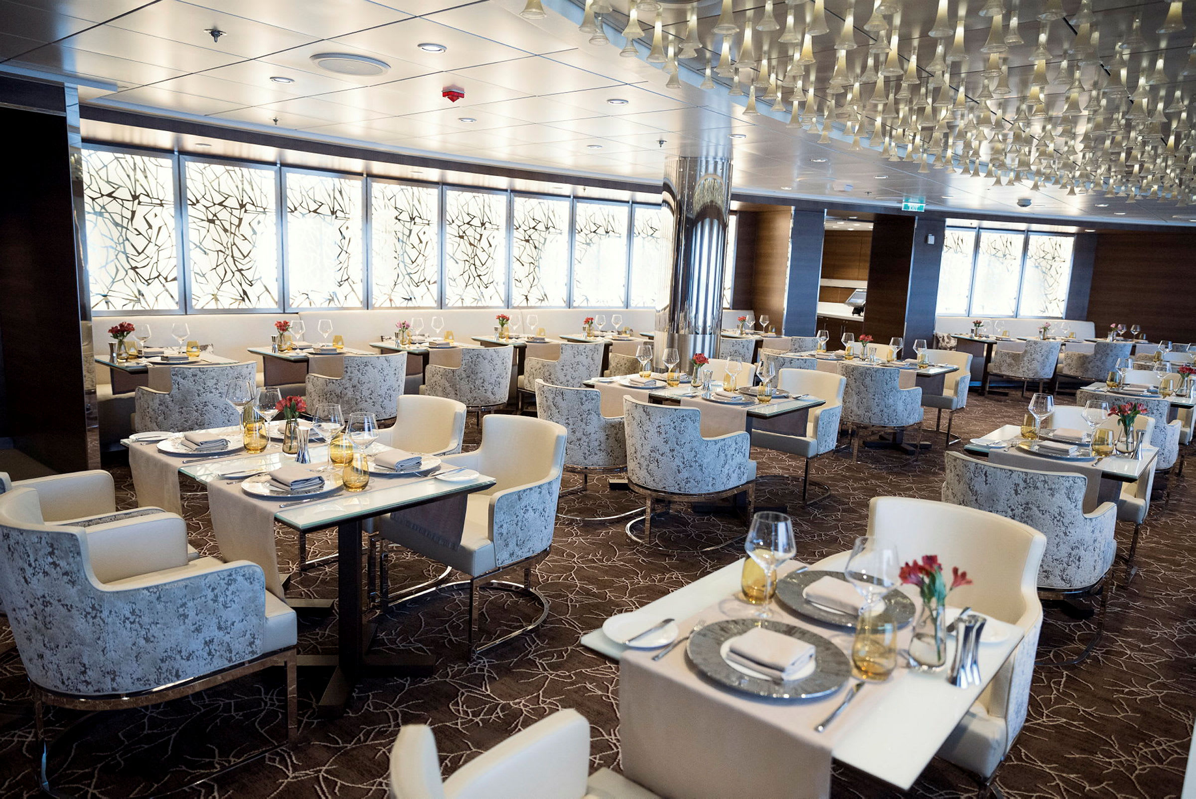 En elegant restaurant med flere bord, dekorert med glass og servietter. (AI-generert tekst)