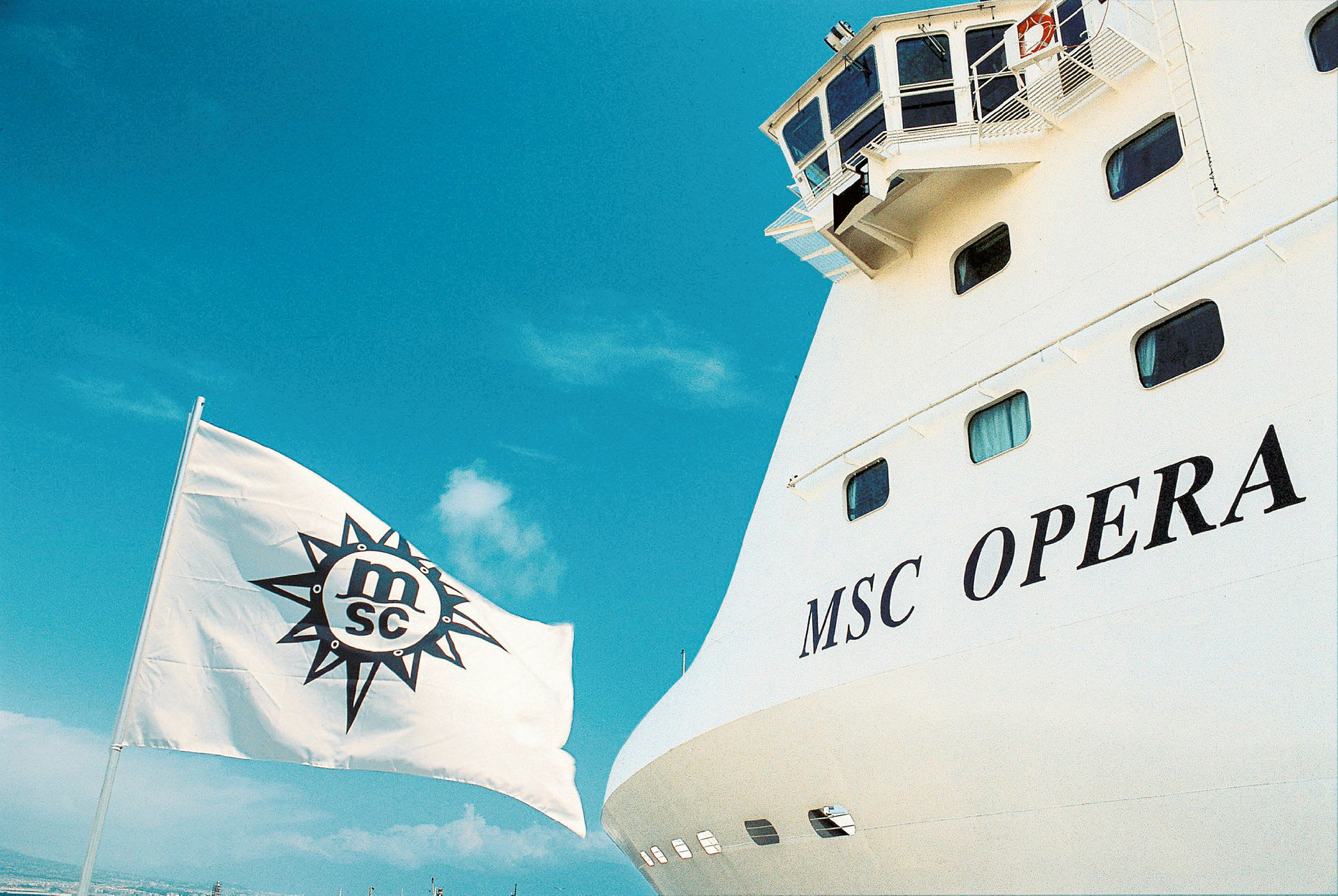 Bilde av skipet MSC Opera med navnet tydelig vist samt et hvitt flagg med MSC-logoen heist. (AI-generert tekst)