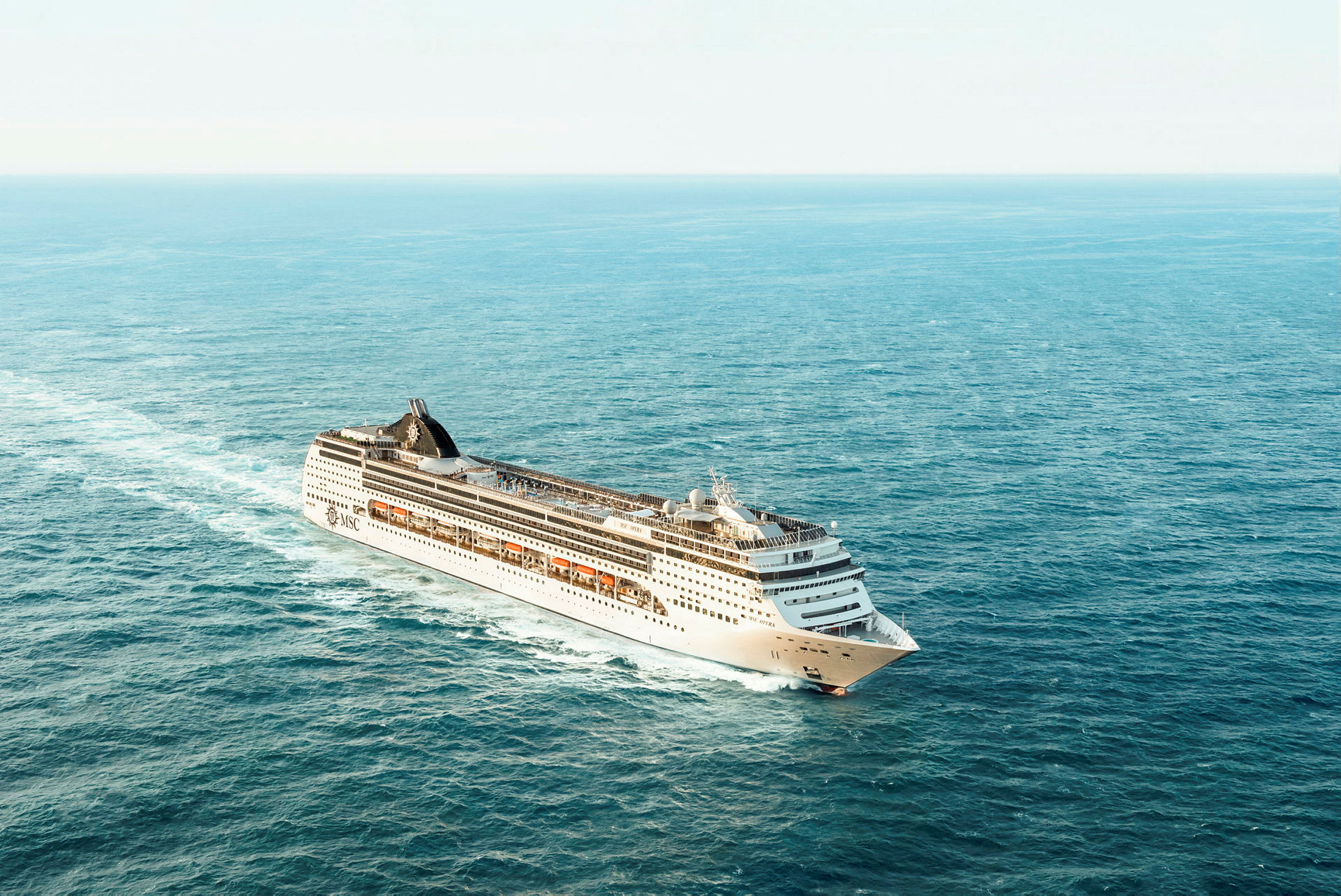 Et stort cruiseskip beveger seg gjennom et åpent hav. (AI-generert tekst)