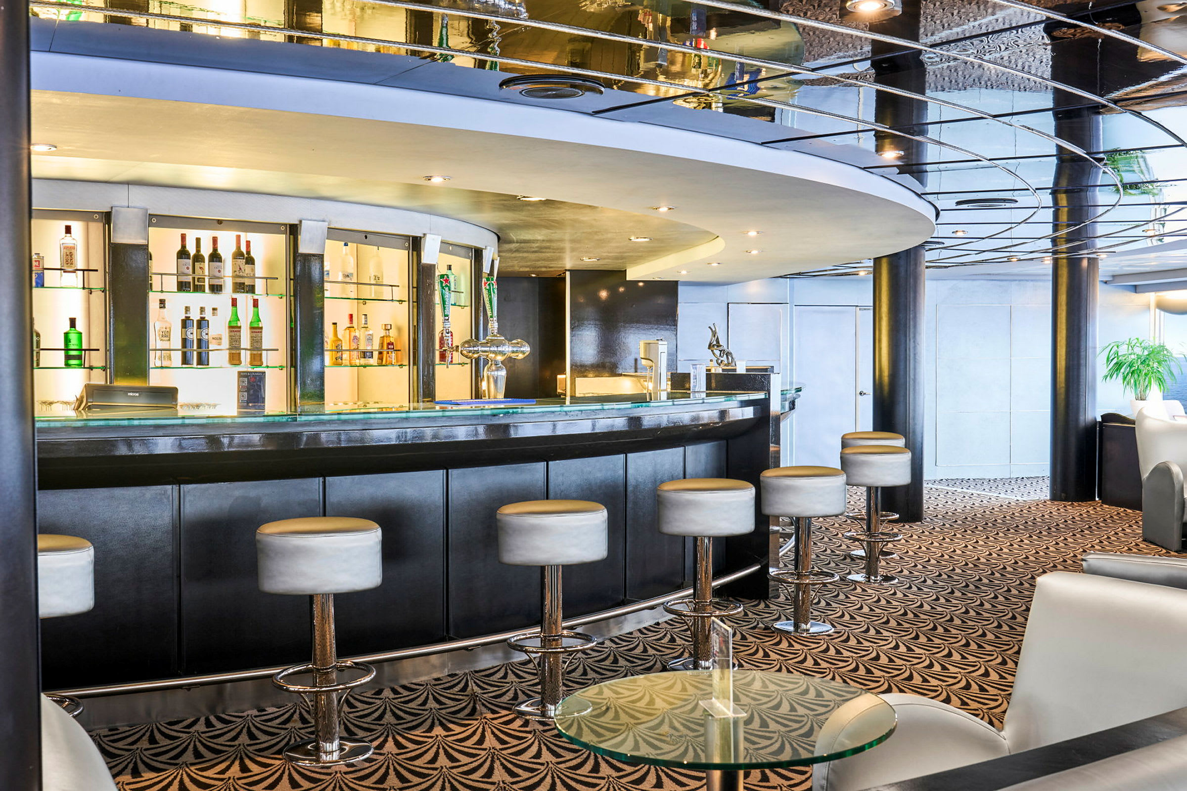 Interiør av en elegant bar med en buet bardisk og høye barstoler. (AI-generert tekst)