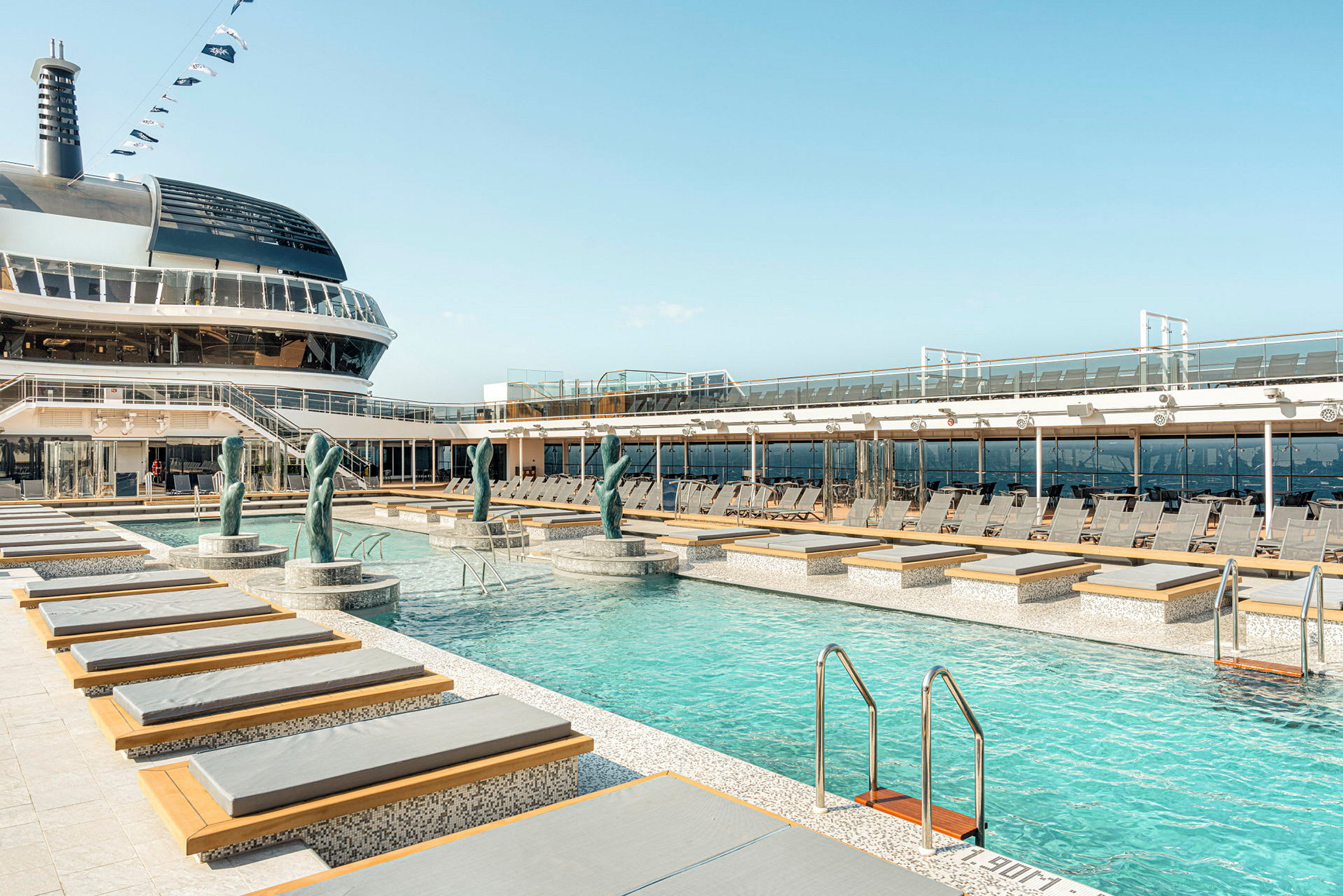 Bassengområde på et cruiseskip, med solsenger og dekorasjoner. Avslapningssted tydelig avgrenset. (AI-generert tekst)