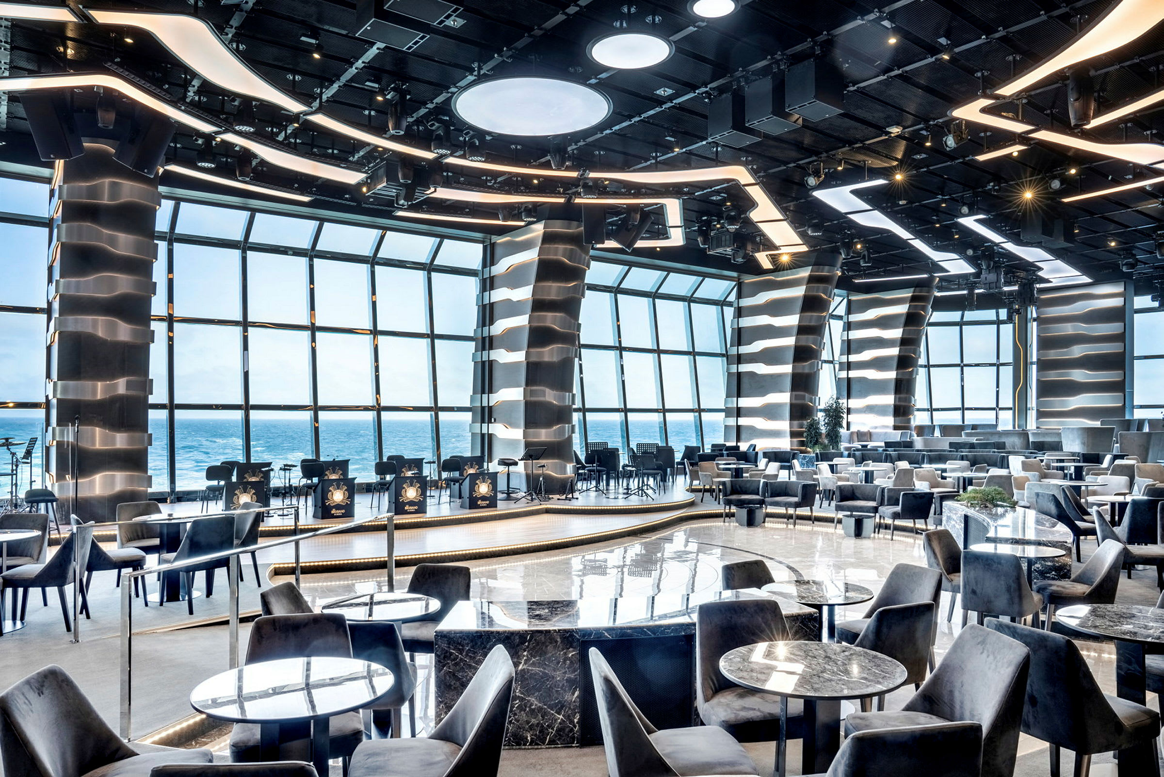 Restaurantmiljø med moderne design og havutsikt gjennom store vinduer. (AI-generert tekst)