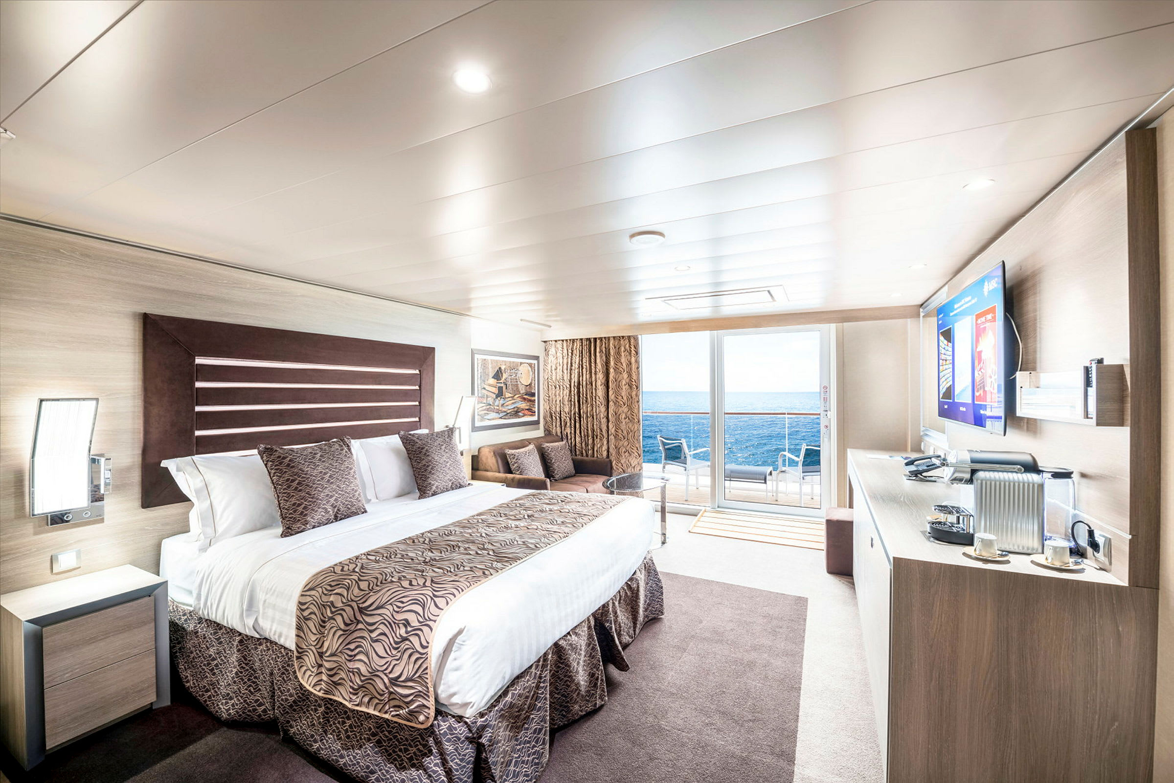 Romslig hotellrom med moderne innredning, havutsikt og møblert balkong. (AI-generert tekst)