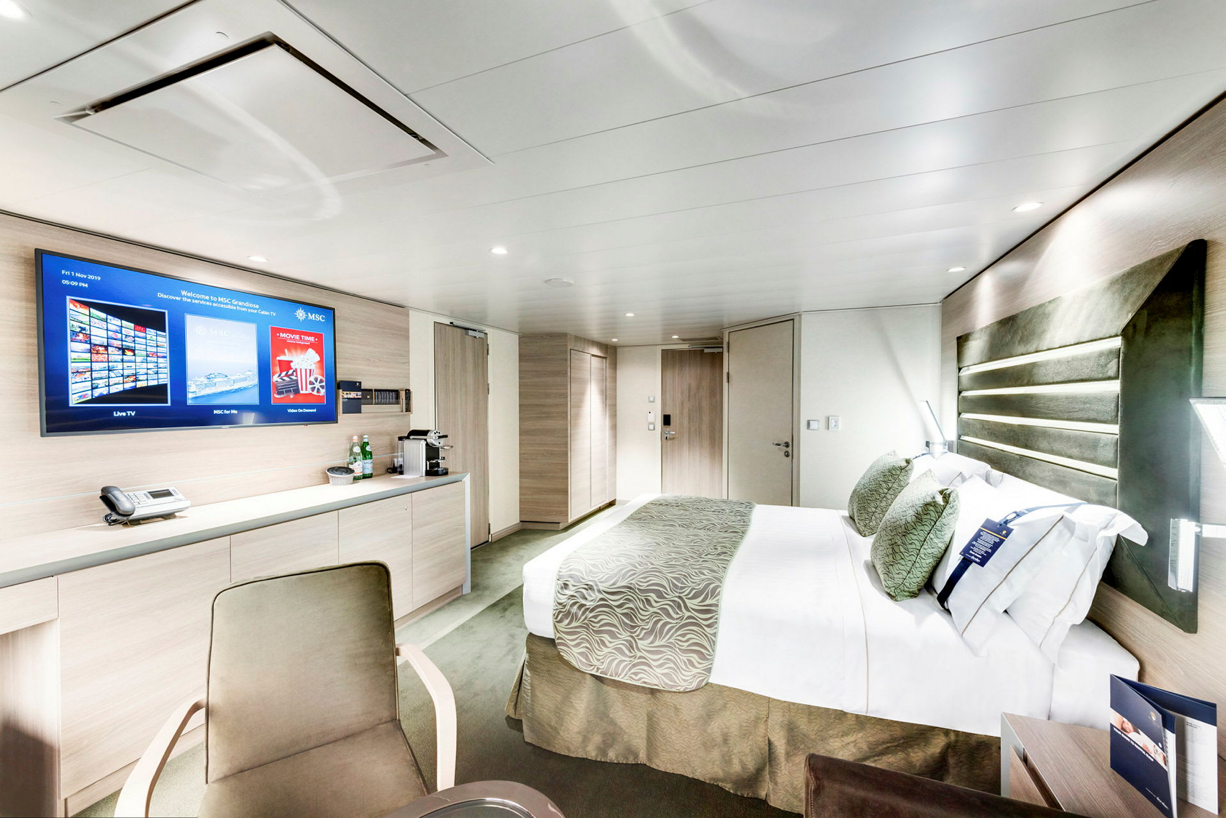 Et moderne hotellrom med seng, skrivebord og TV. (AI-generert tekst)