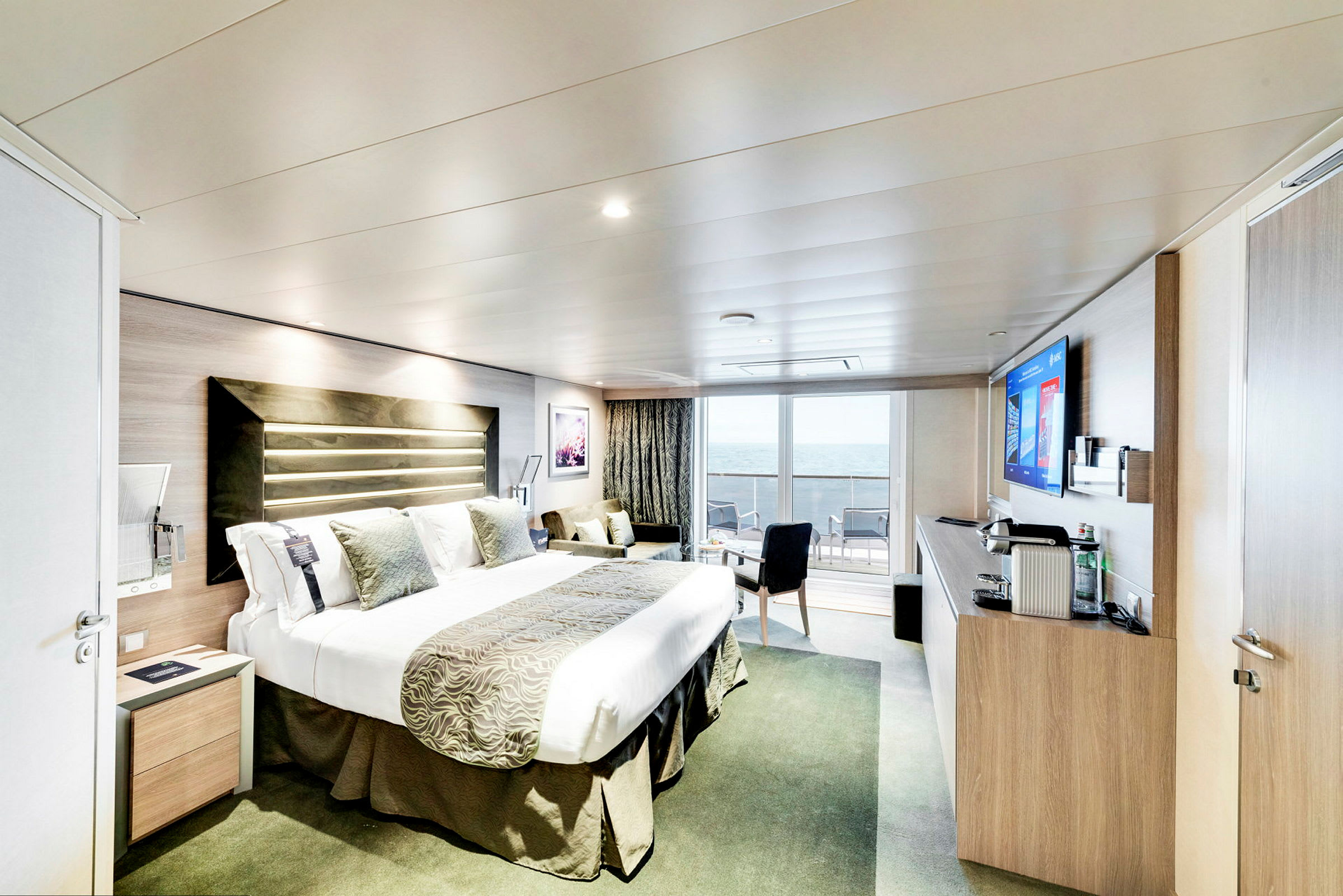 Hotellrom med dobbeltseng og utsikt over havet fra balkongen. (AI-generert tekst)