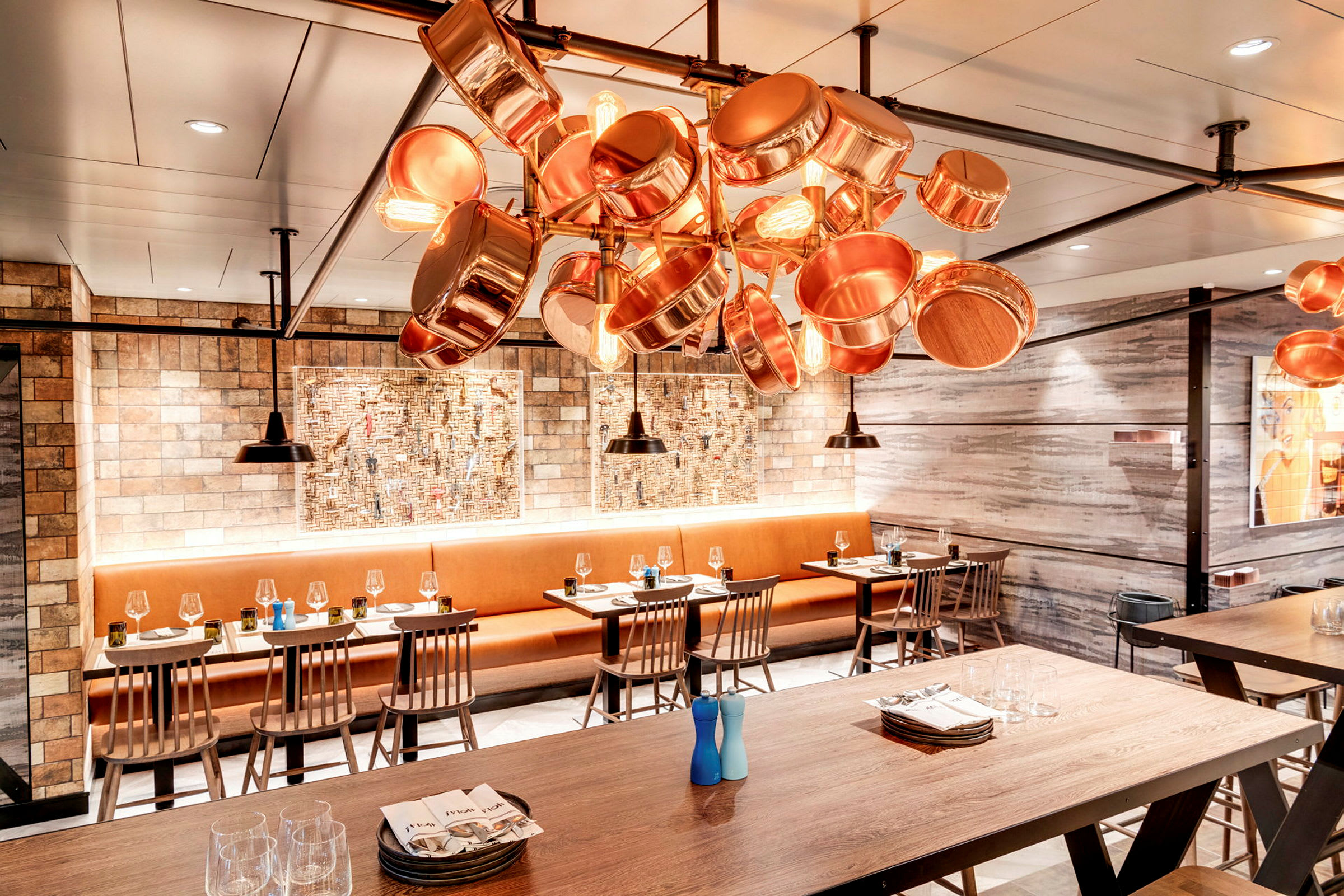 Restaurant med trebord, stoler og taklampe av kobberkar. (AI-generert tekst)