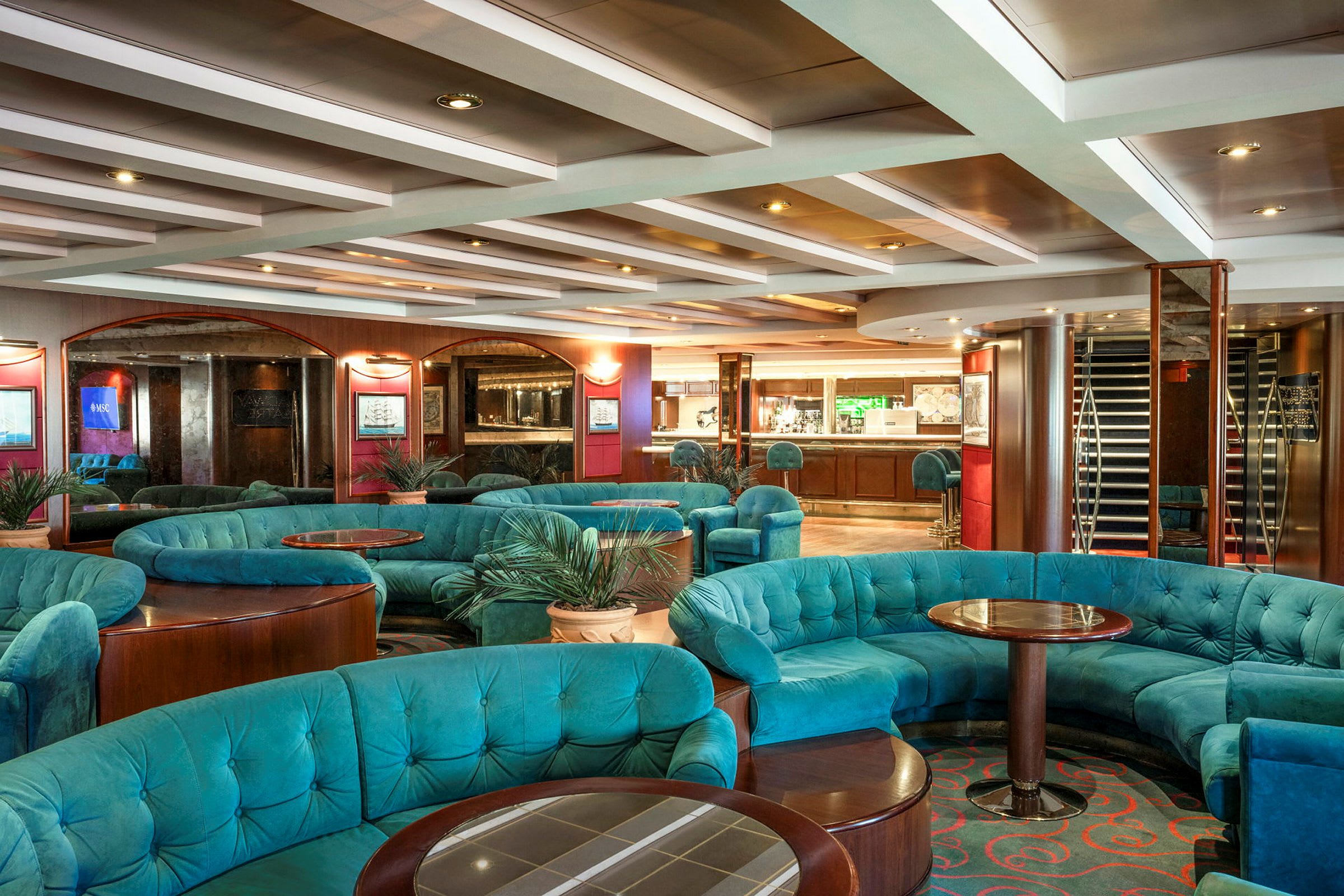 En elegant lounge med turkise sofaer, runde bord og en innbydende atmosfære. (AI-generert tekst)