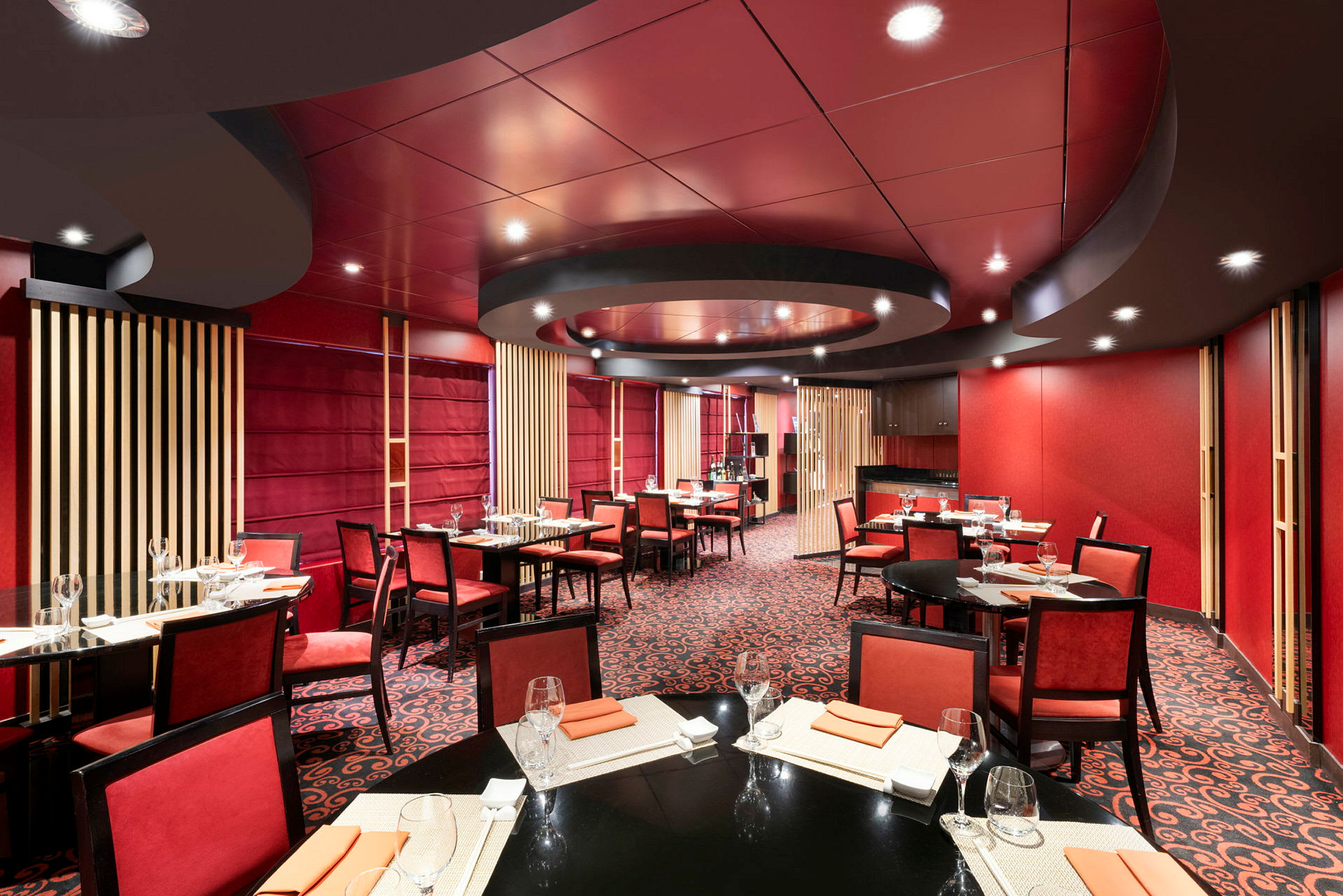 Interiør av en restaurant med rødt fargetema og dekkede bord. (AI-generert tekst)