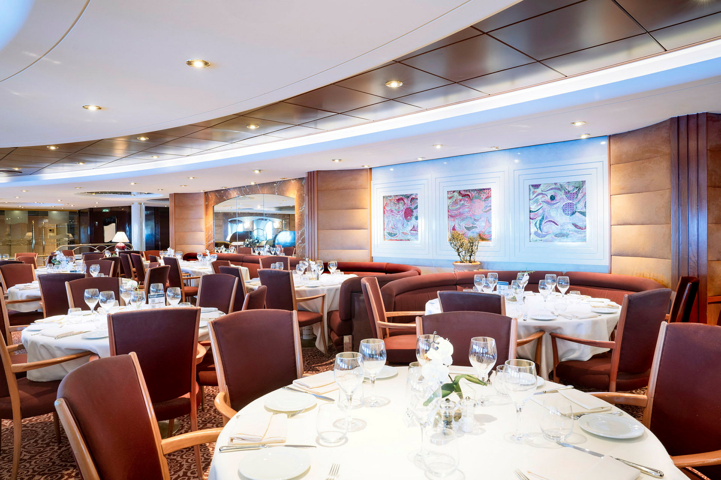 En elegant restaurant med dekkede bord og stoler rundt dem. (AI-generert tekst)