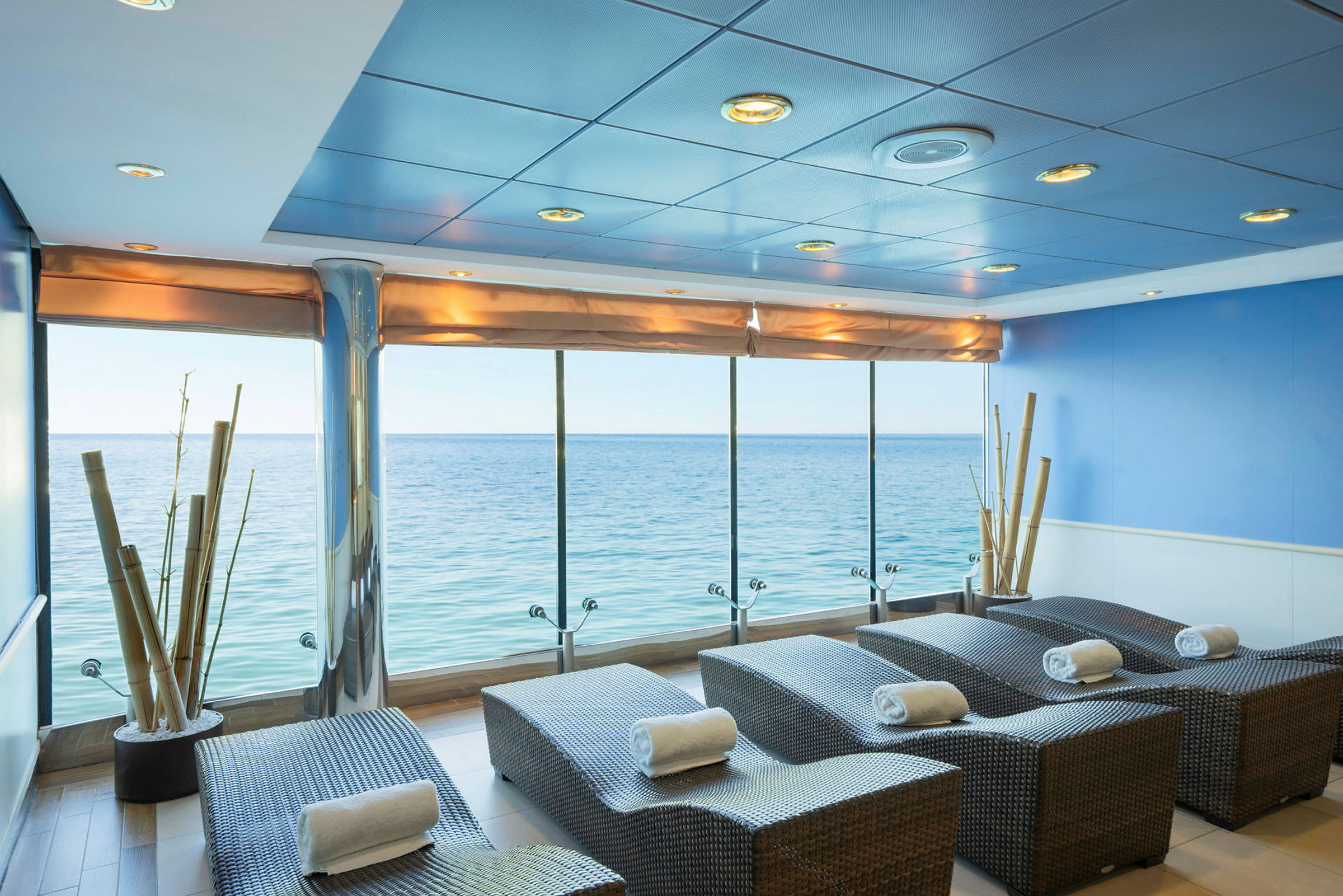 Spa-lounge med utsikt over havet, solsenger dekket med håndklær. (AI-generert tekst)
