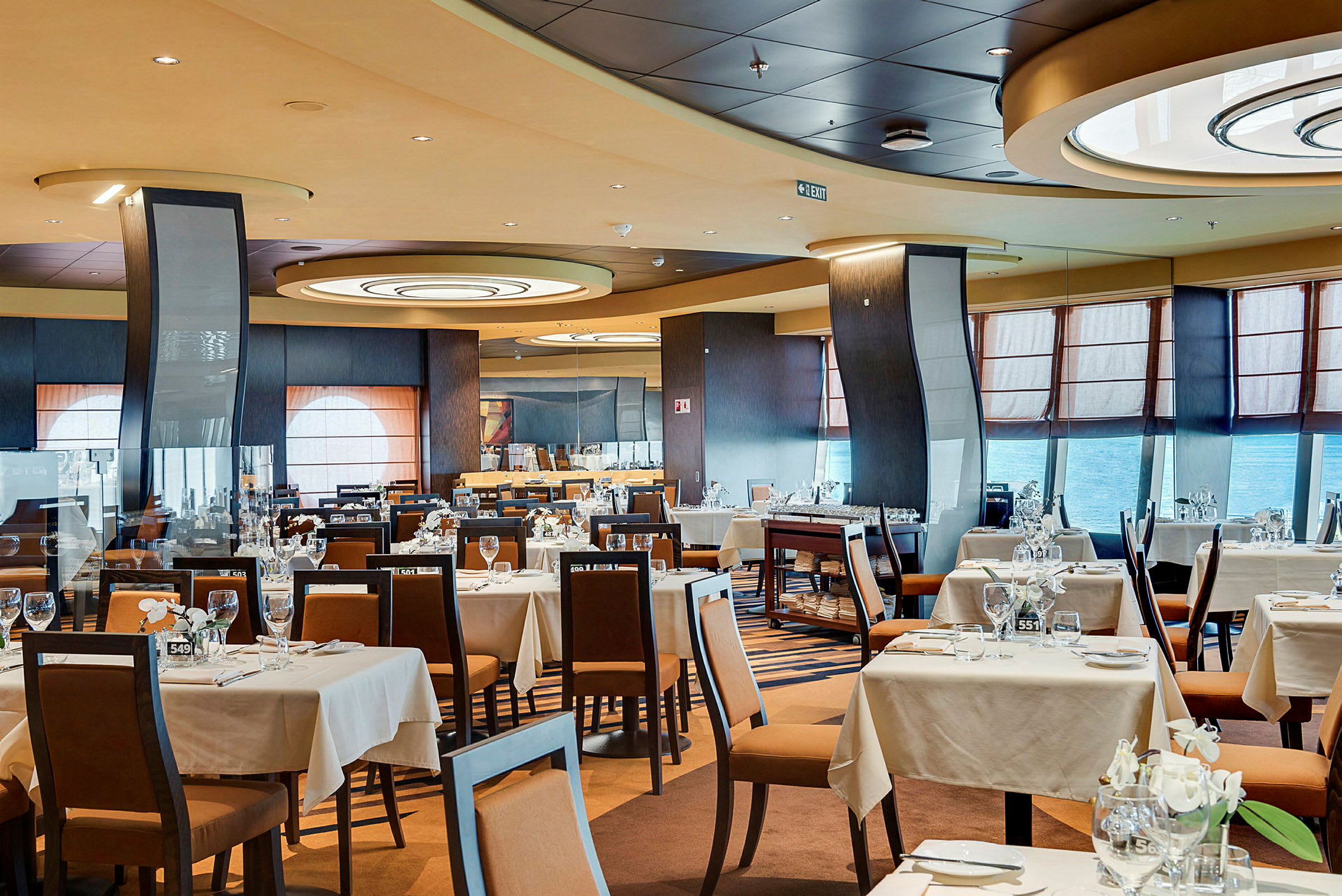 Interiør av en romslig restaurant med dekkede bord og stoler. (AI-generert tekst)