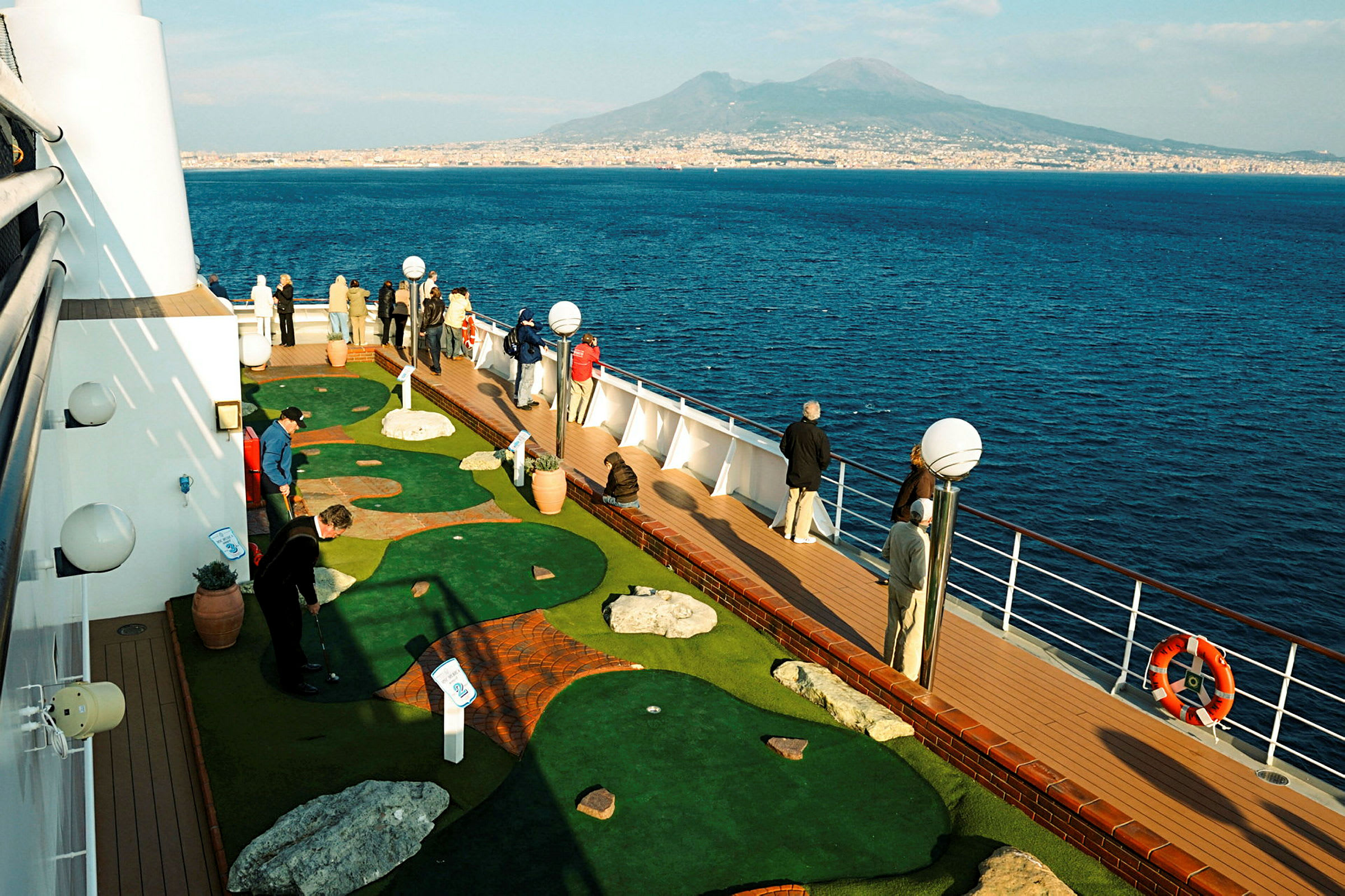 Passasjerer spiller minigolf på dekk på et cruiseskip. (AI-generert tekst)