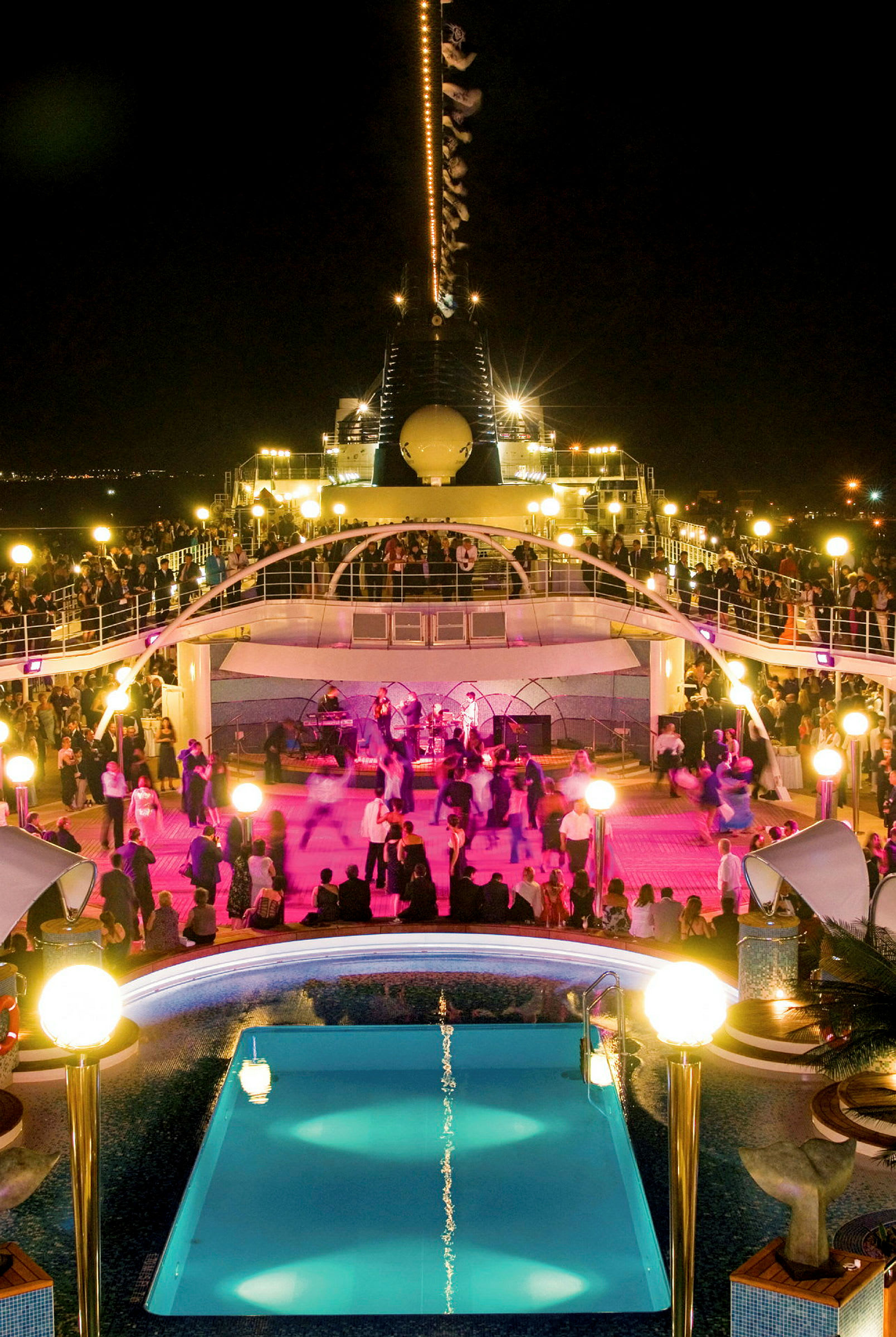Folk danser og sosialiserer ved bassenget på et cruiseskip om natten. (AI-generert tekst)