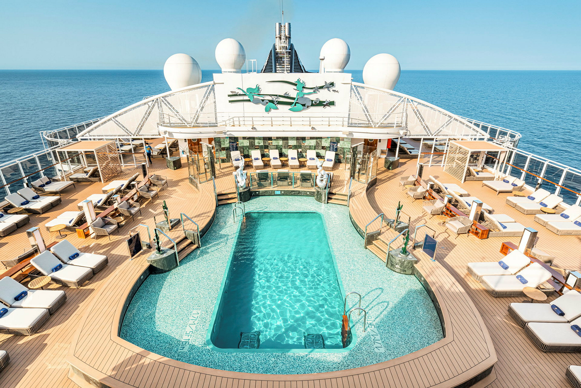 En solterrasse på et cruiseskip med solsenger og et rektangulært basseng. (AI-generert tekst)
