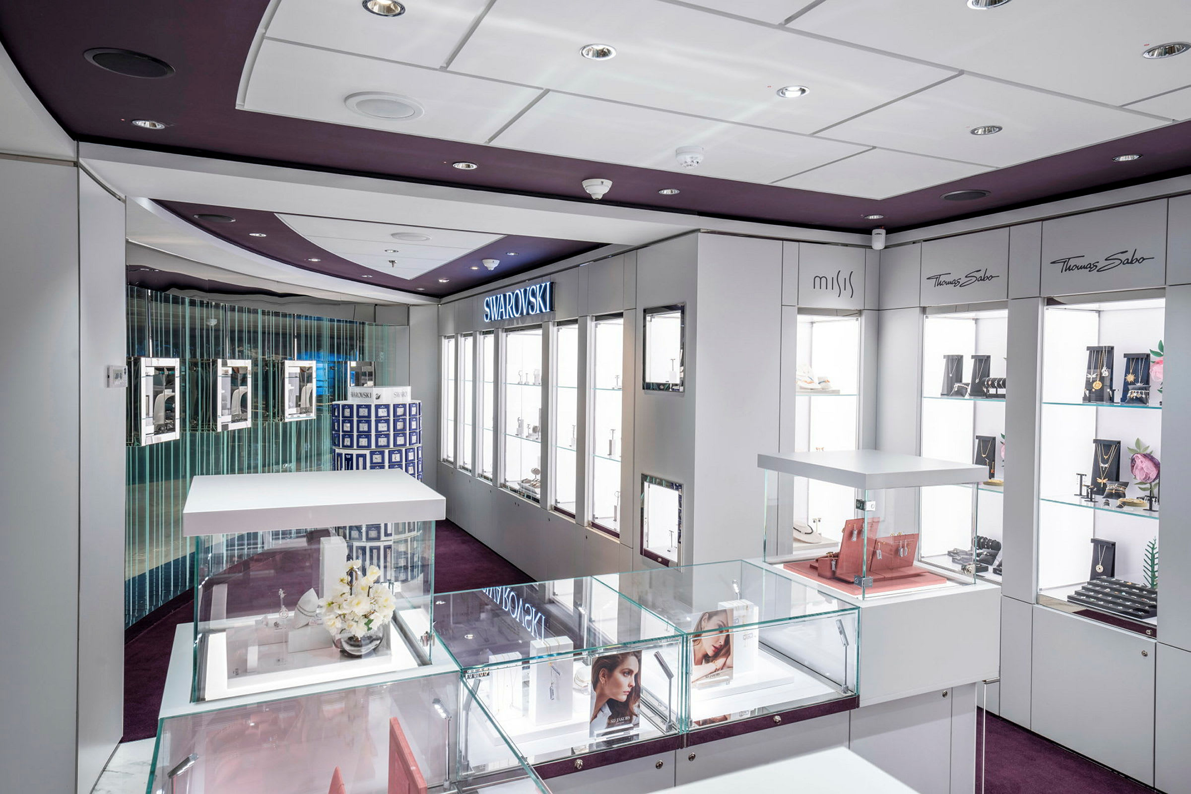 En moderne smykkebutikkinteriør med glassmontrer og merkevarer som Swarovski og Thomas Sabo. (AI-generert tekst)
