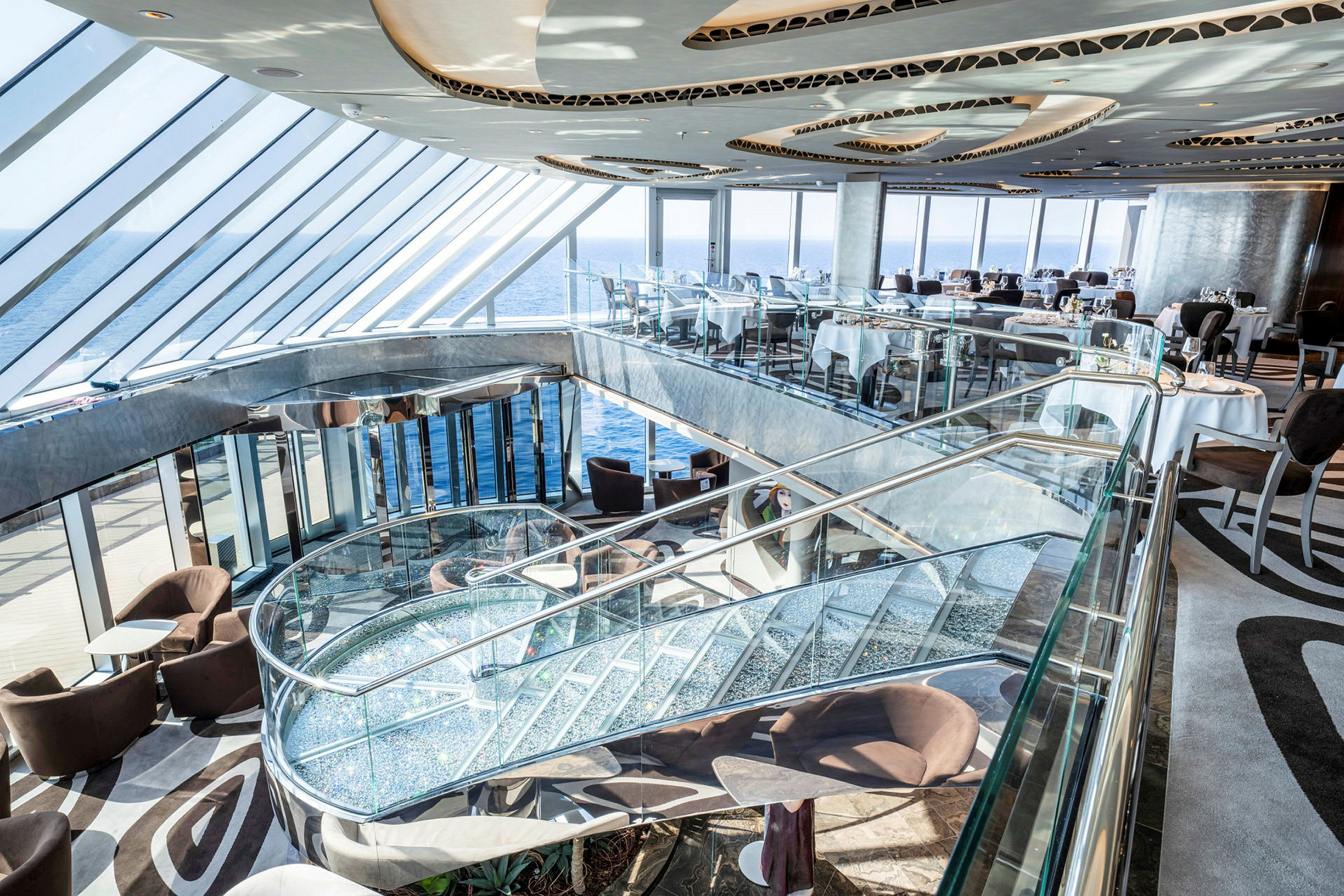 En moderne restaurant med glasspartier og utsikt over havet. (AI-generert tekst)