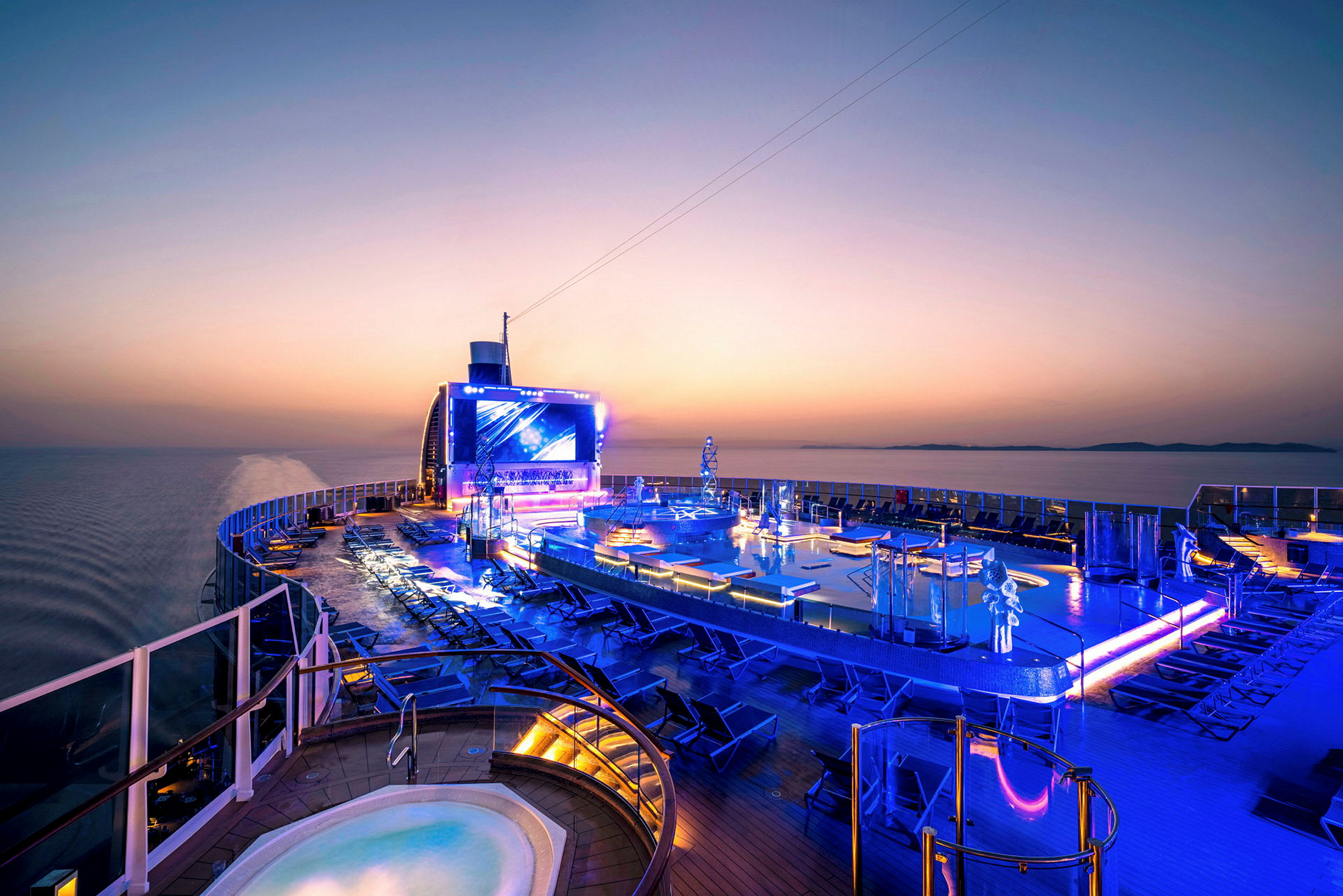 Bassengområde på et cruiseskip ved solnedgang. (AI-generert tekst)