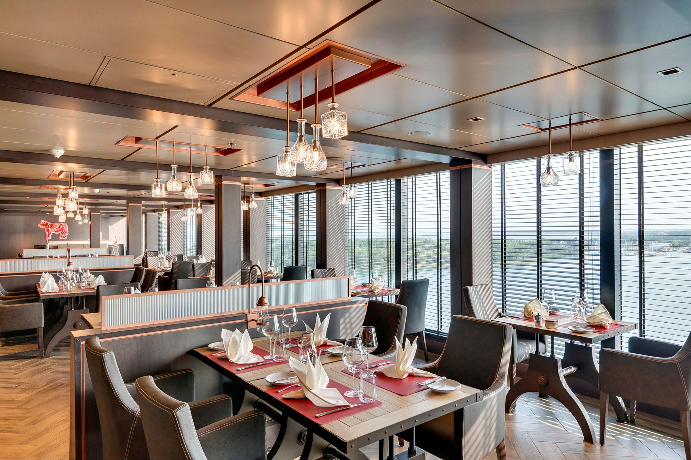 Restaurant med bord, stoler og servietter, store vinduer med utsikt. (AI-generert tekst)