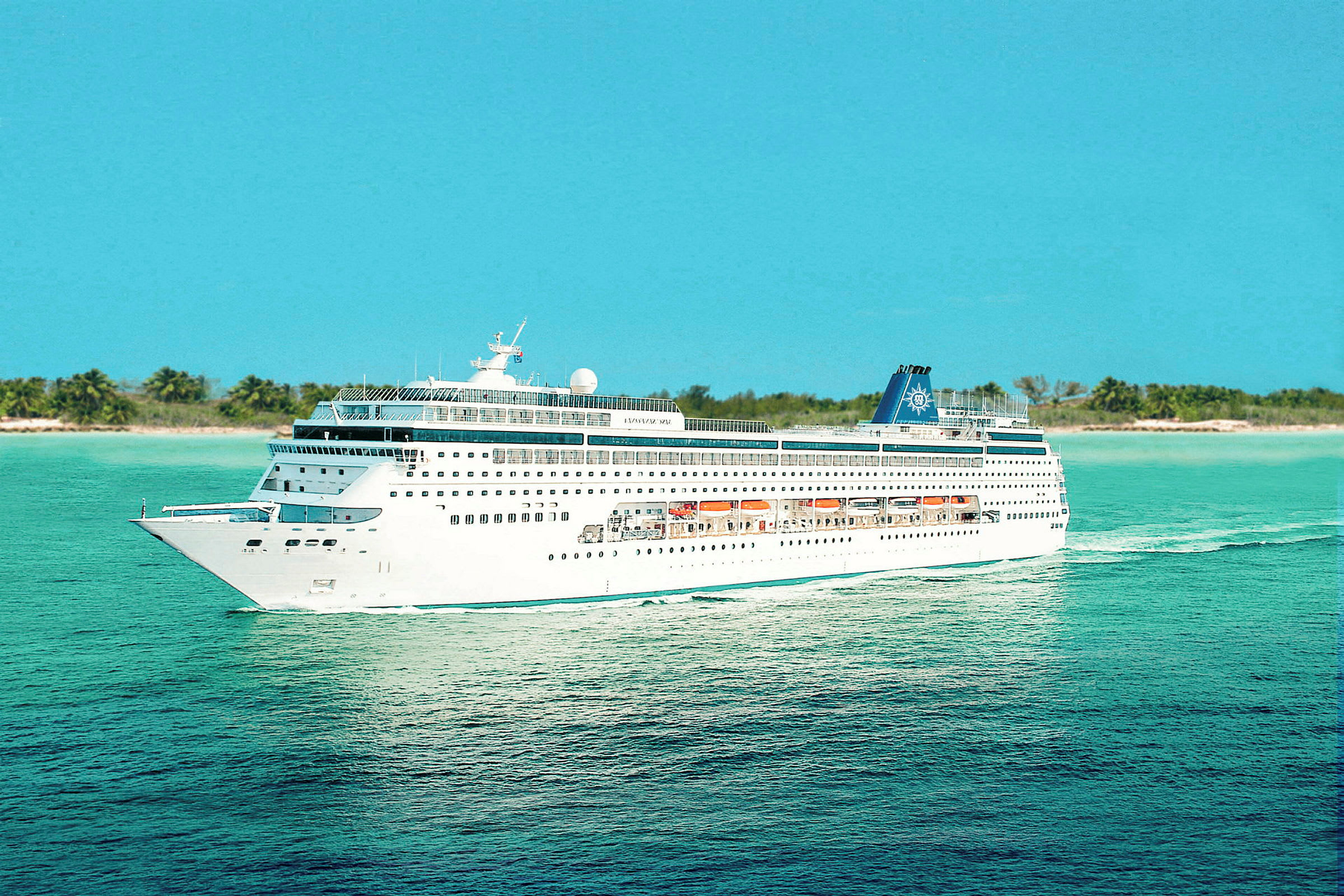 Et cruiseskip seiler på et turkist hav, med en strandlinje og palmer i bakgrunnen. (AI-generert tekst)
