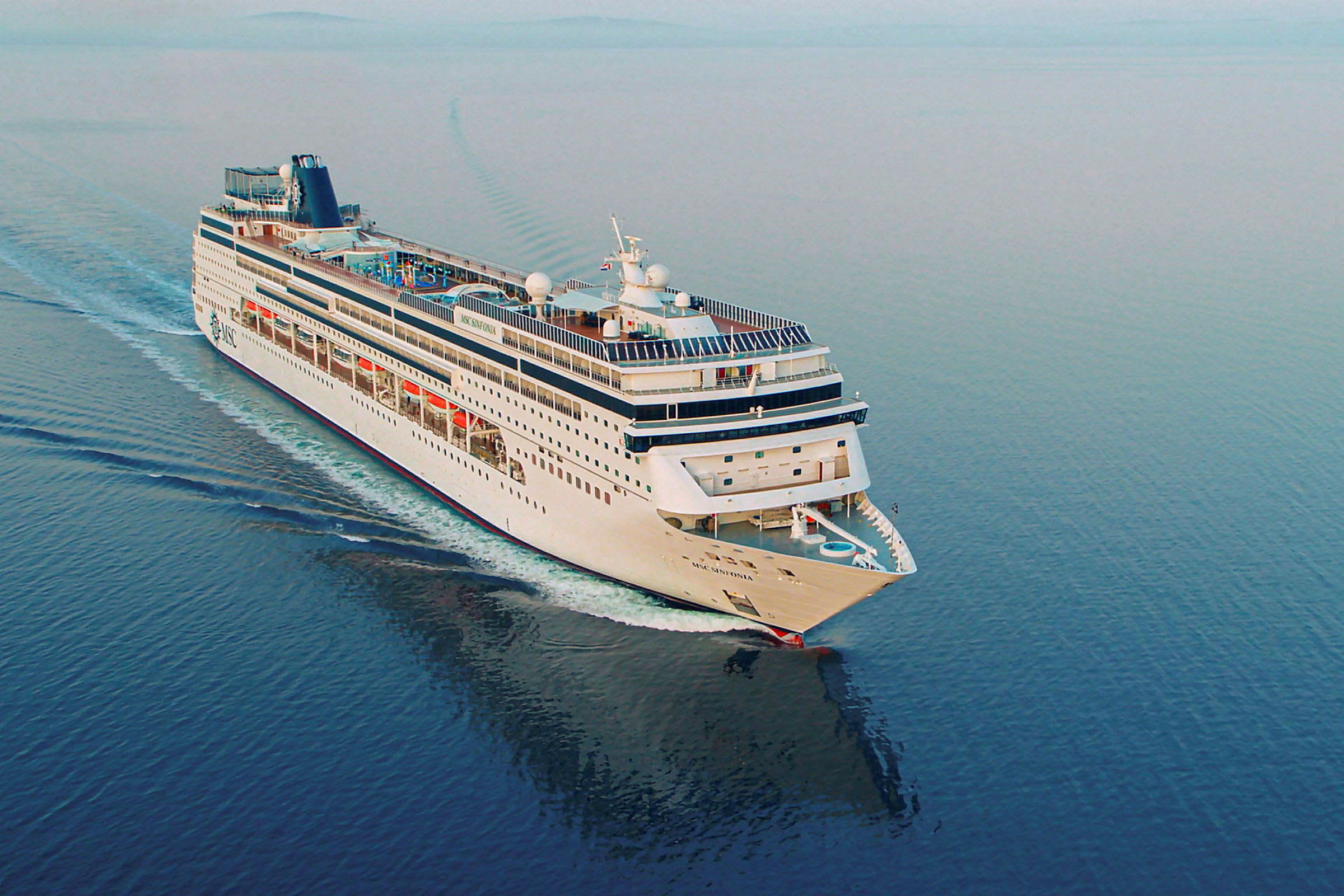 Et cruiseskip seiler på et rolig hav. (AI-generert tekst)