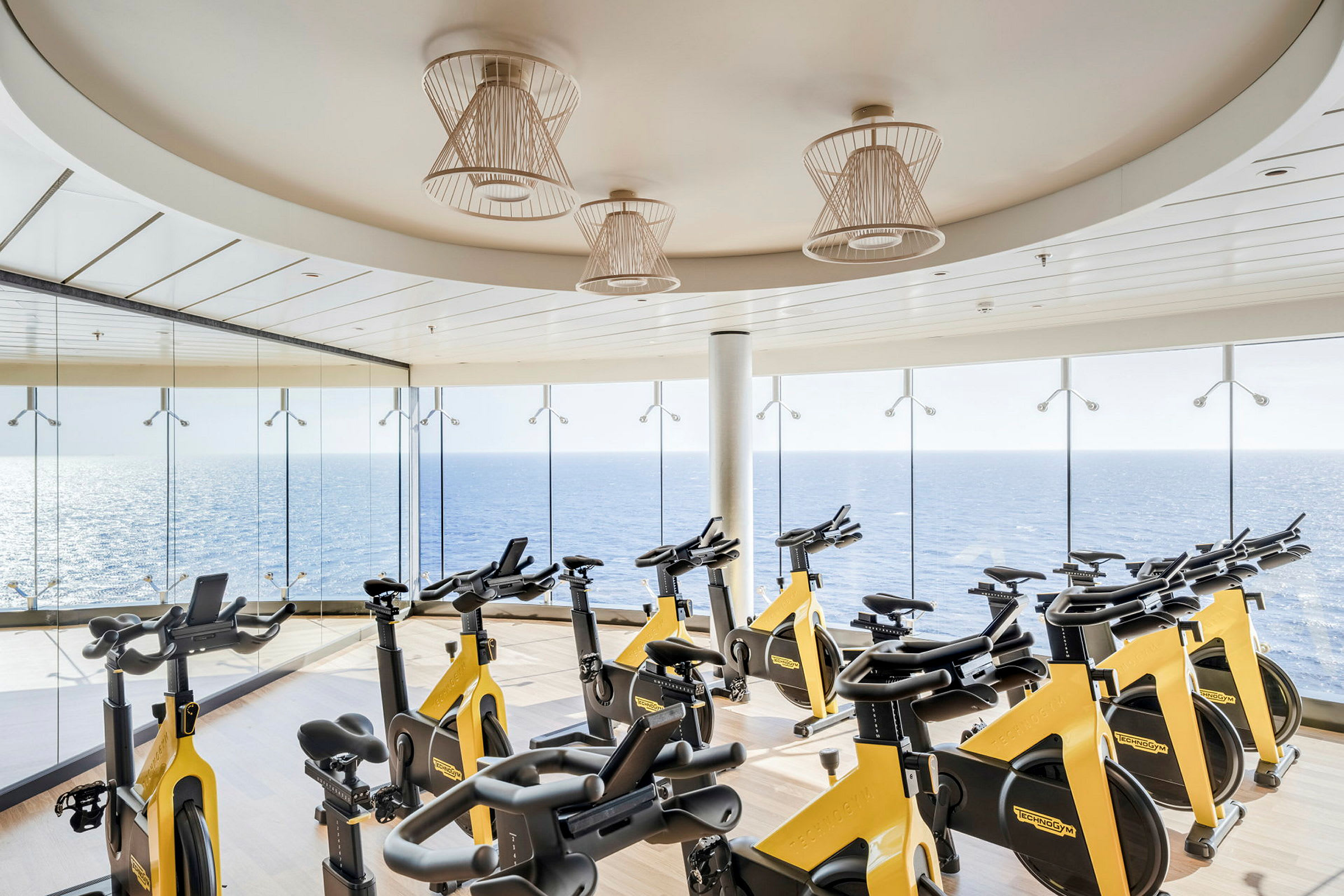 Elliptiske treningsapparater på et treningsstudio med vinduer mot havet. (AI-generert tekst)