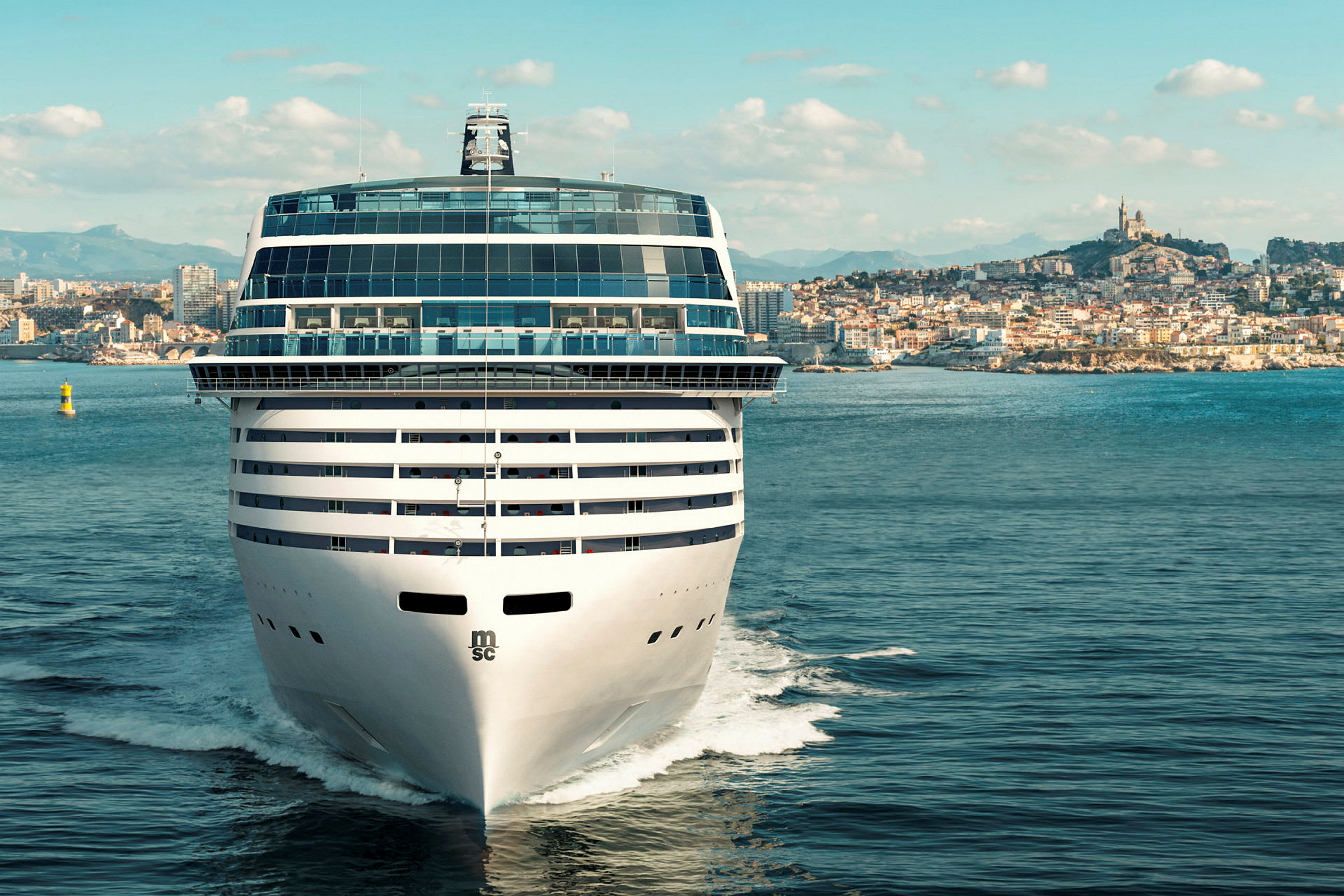 Et stort cruiseskip nærmer seg en kystby med historisk arkitektur. (AI-generert tekst)
