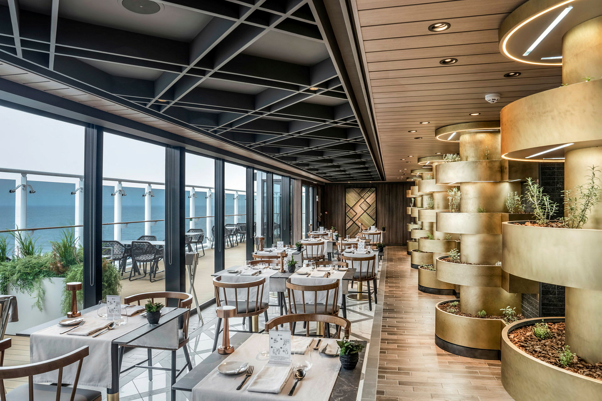 En restaurant med bord og stoler nær store vinduer, dekorert med planter og moderne interiør. (AI-generert tekst)