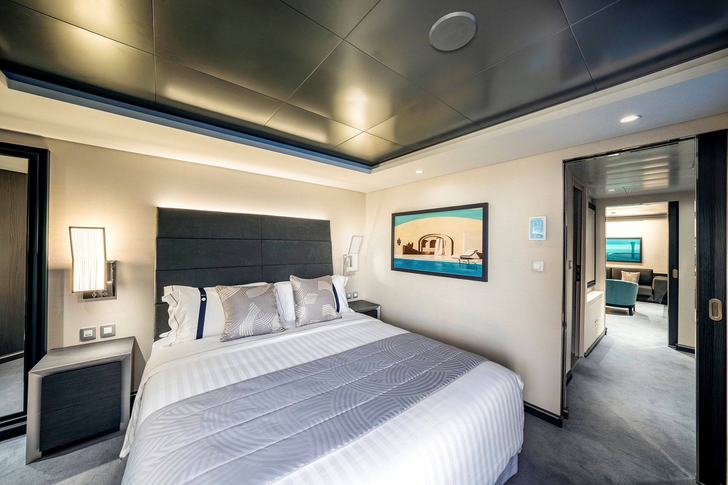 Hotellrom med seng og dekorativt kunstverk på veggen. (AI-generert tekst)