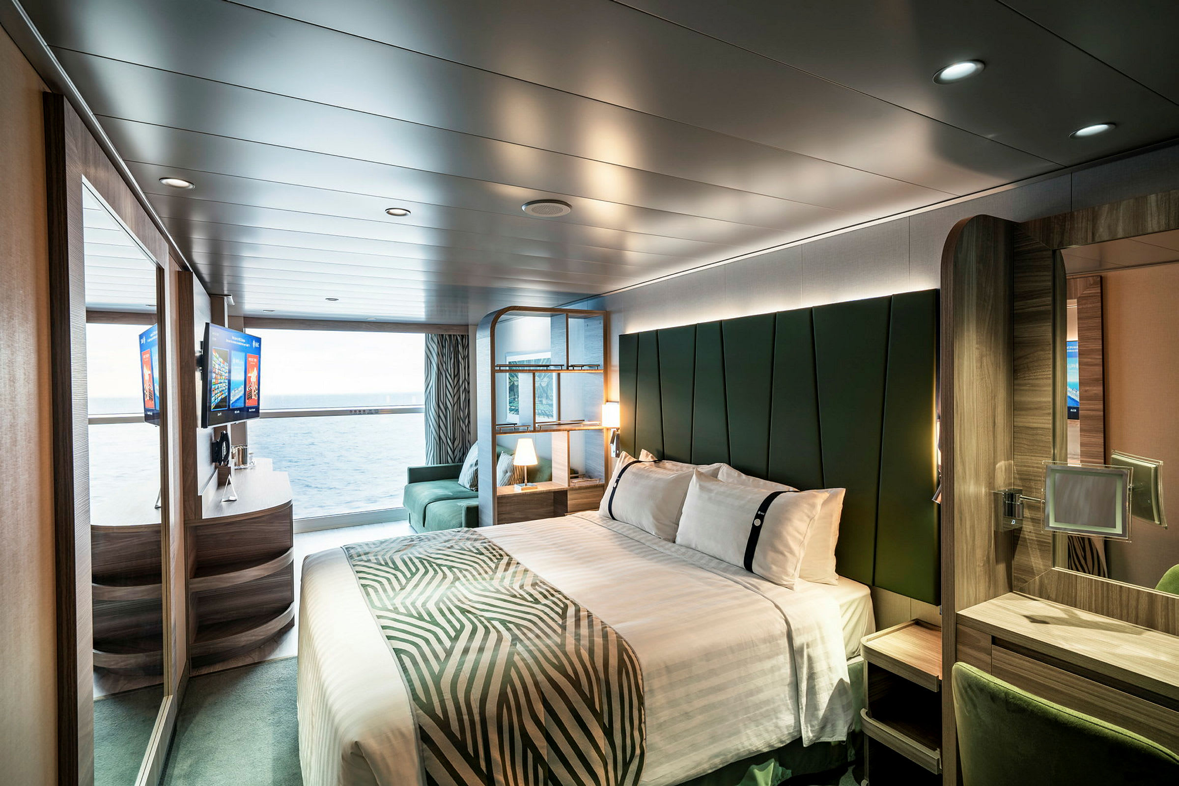 Interiør av et moderne hotellrom med seng, sittemøbler og havutsikt. (AI-generert tekst)