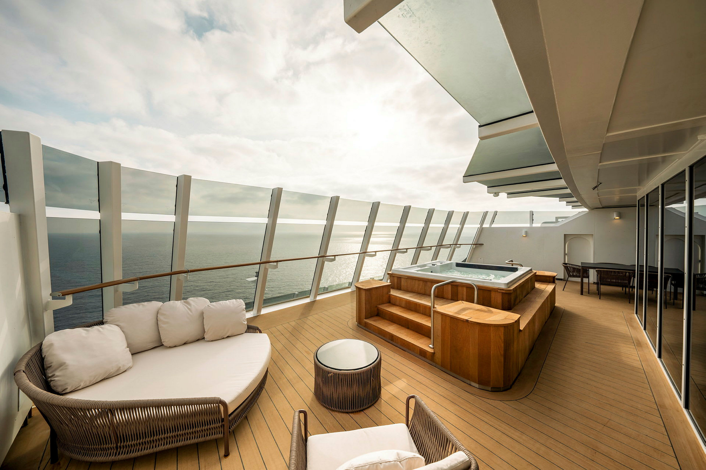 Privat terrasse med boblebad, sittemøbler og utsikt over havet. (AI-generert tekst)