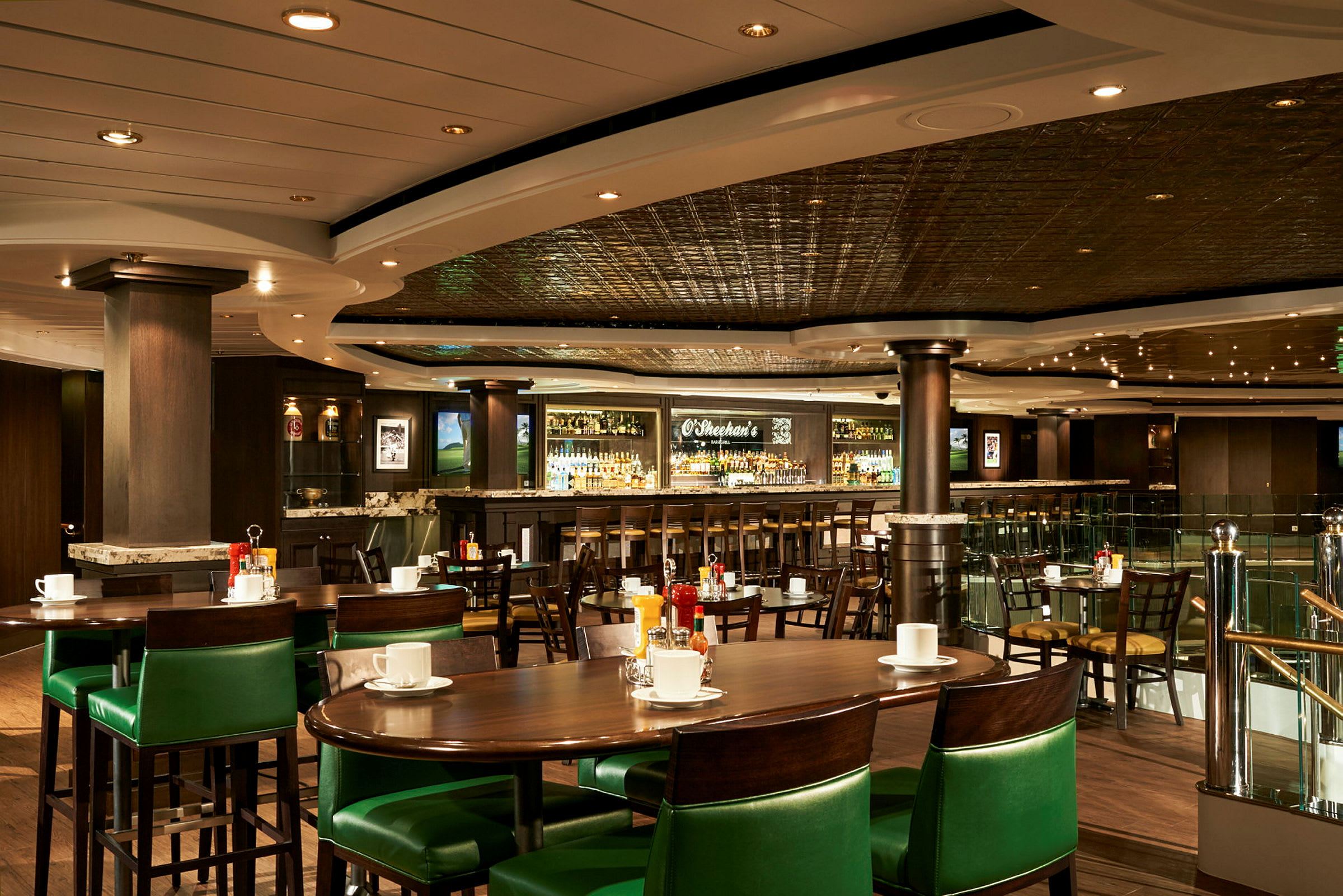 Bilde av en restaurant med grønne stoler, bord og en bar i bakgrunnen. (AI-generert tekst)