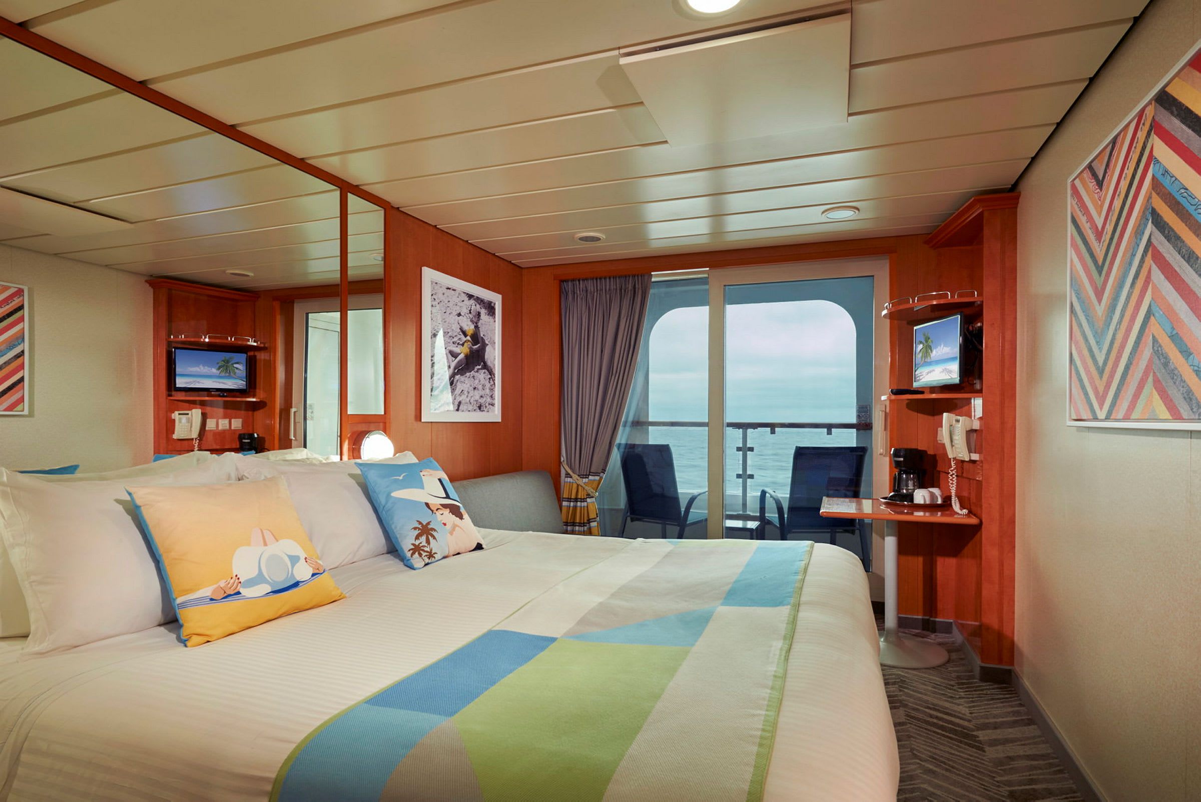 Lugaren på et cruiseskip med dobbeltseng, dekorative puter og balkong med havutsikt. (AI-generert tekst)
