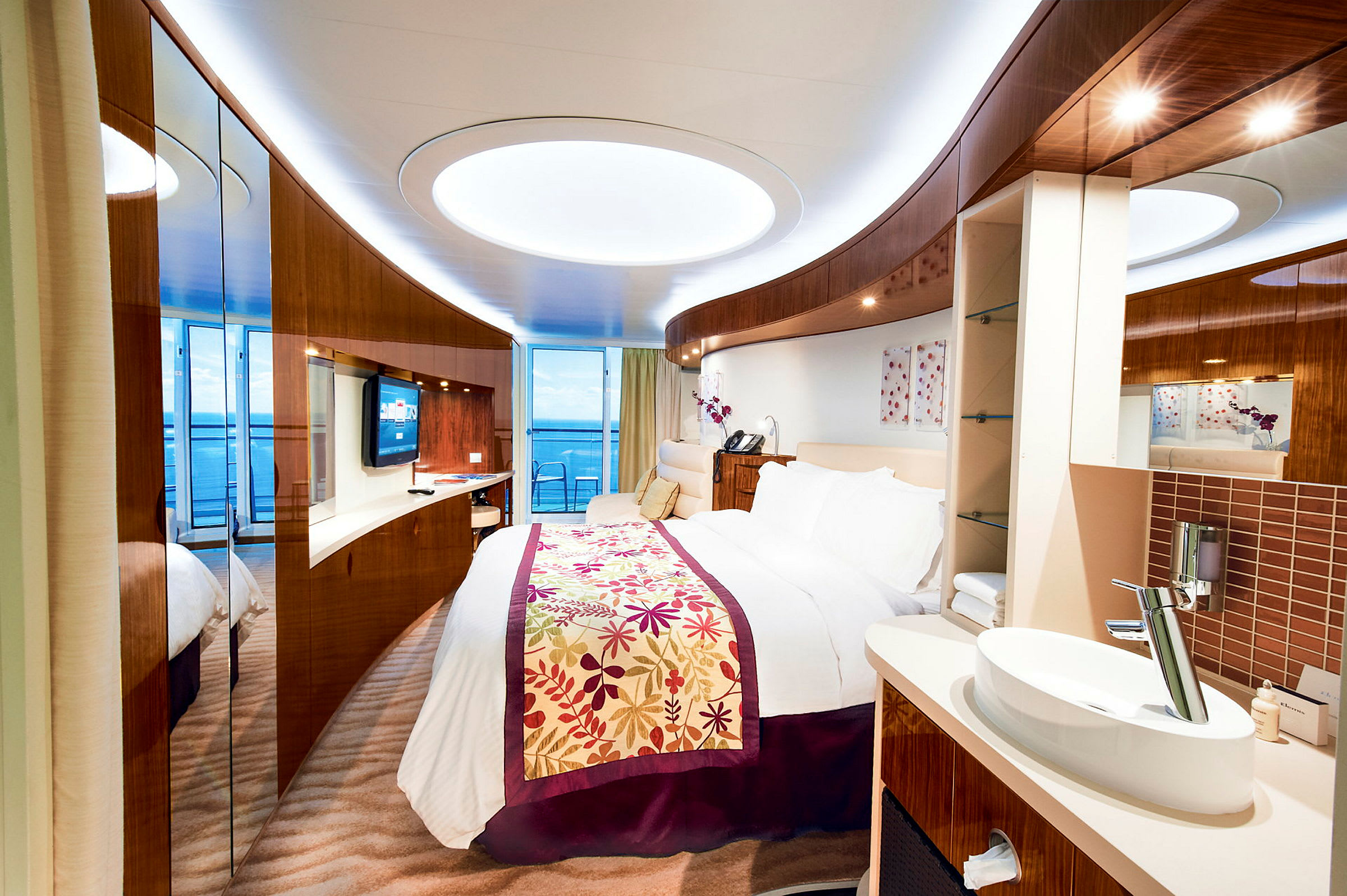 Moderne hotellrom med stor seng, skap og havutsikt fra balkong. (AI-generert tekst)