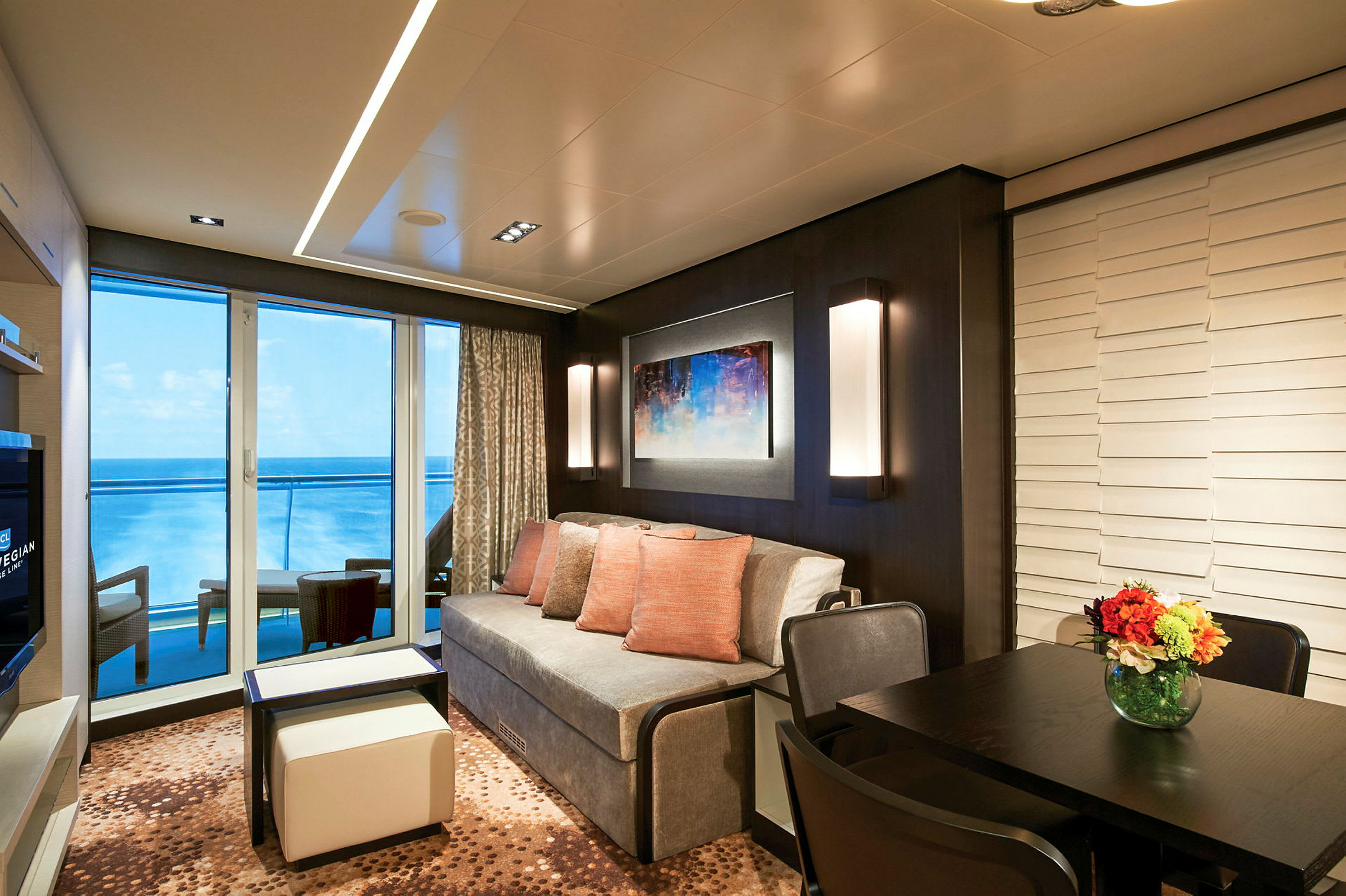 Moderne innredet rom med sofa, bord og utsikt over havet. (AI-generert tekst)