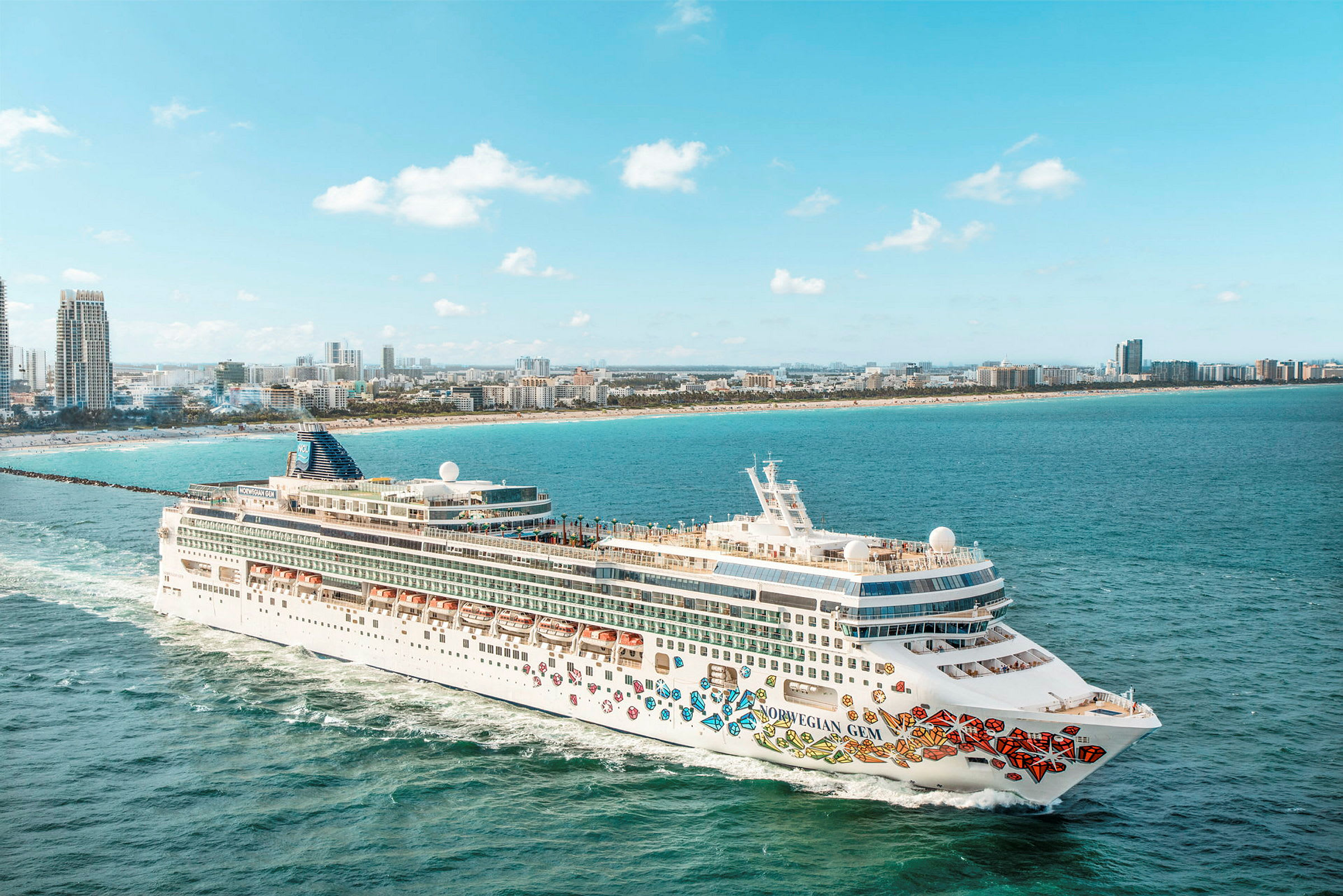 Et cruiseskip på vannet med en by i bakgrunnen. (AI-generert tekst)
