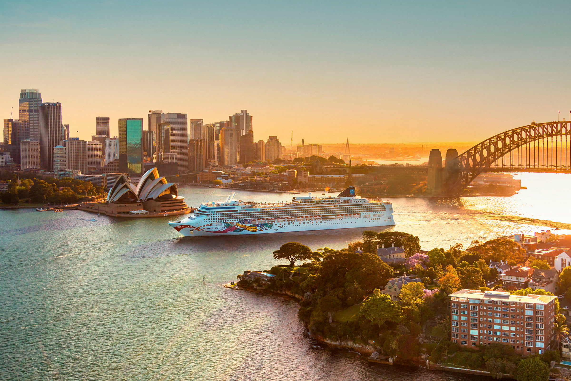 Et cruiseskip passerer Sydney Opera House og Sydney Harbour Bridge. (AI-generert tekst)