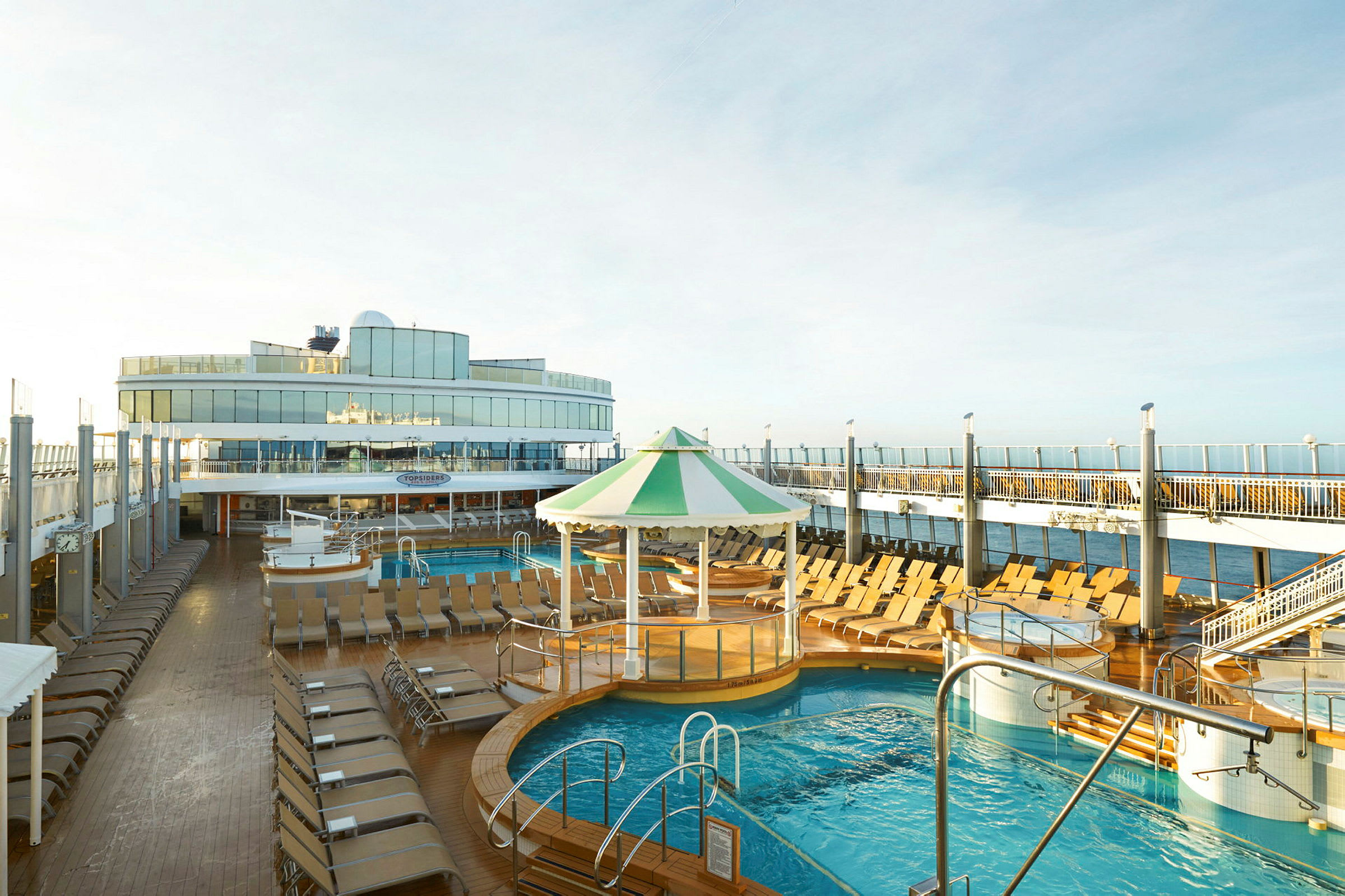 Soldekk på et cruiseskip med basseng og solsenger. (AI-generert tekst)