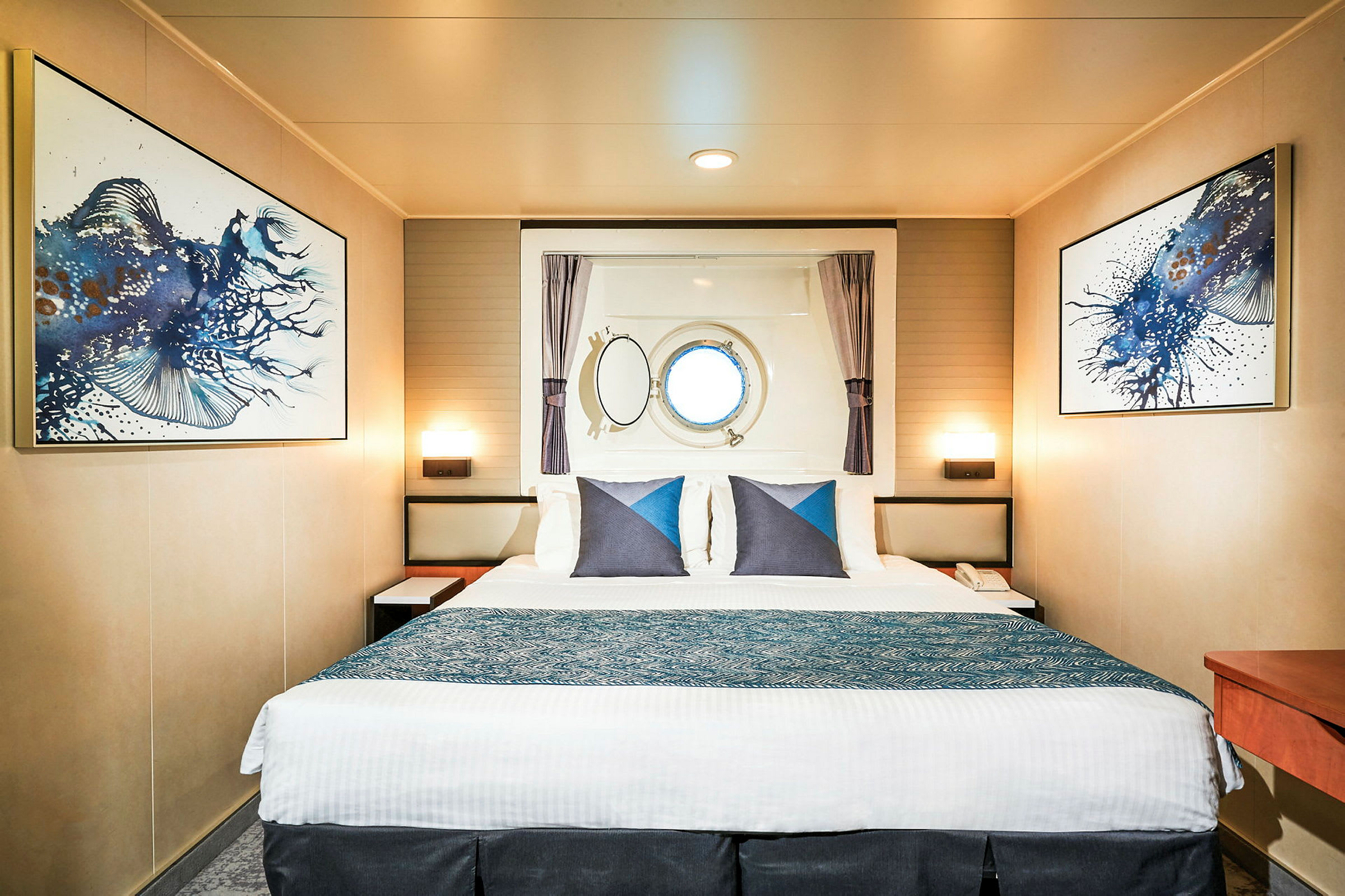Et hotellrom med en stor dobbeltseng, veggkunst og et rundt vindu. (AI-generert tekst)