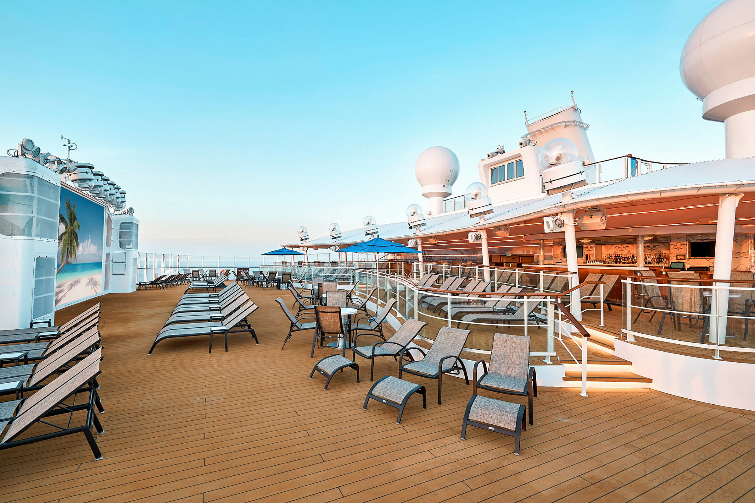 Utendørsdekk på cruiseskip med solsenger, bord og stoler. (AI-generert tekst)