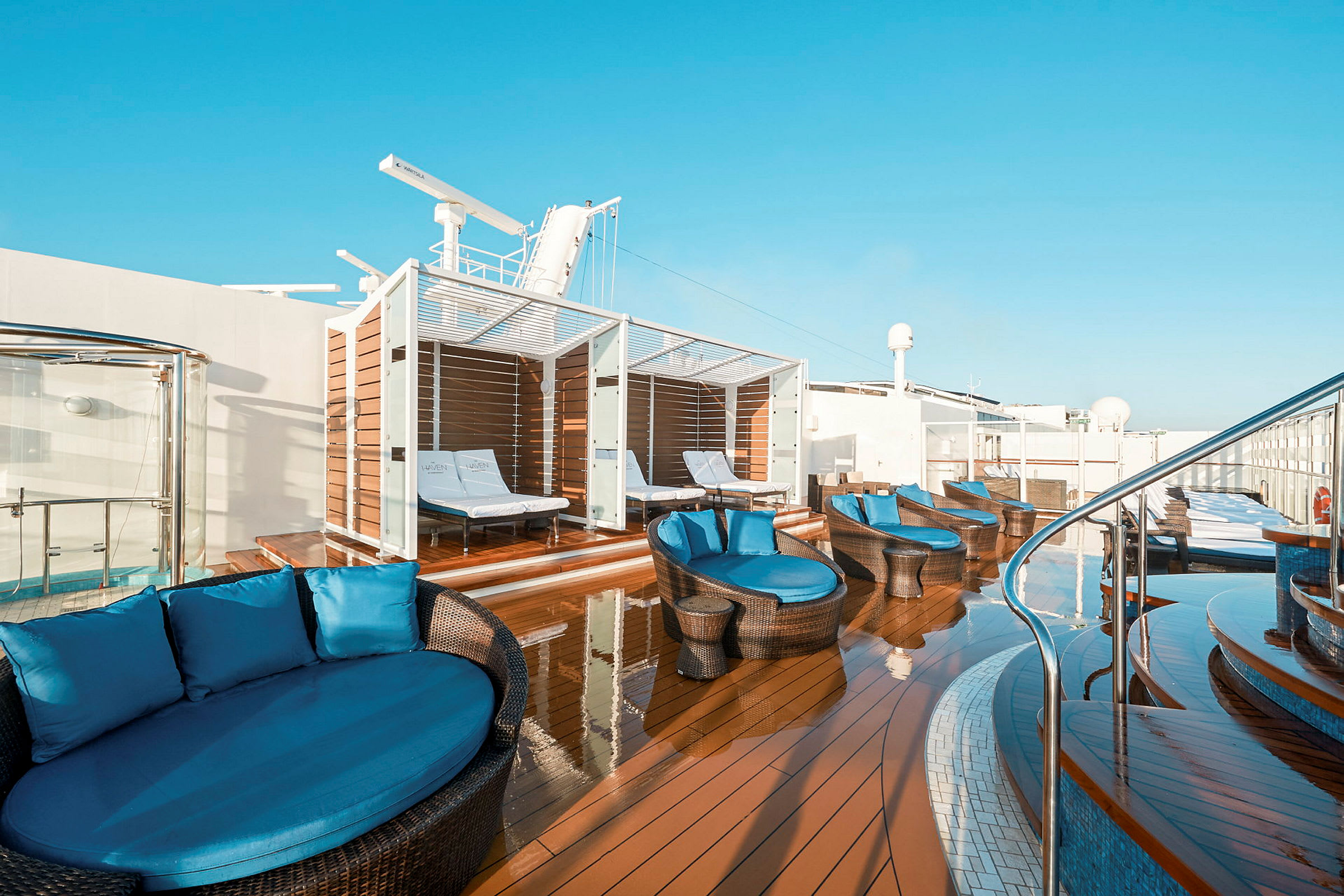 Bilde av en solterrasse med solsenger og sofaer under tak. (AI-generert tekst)