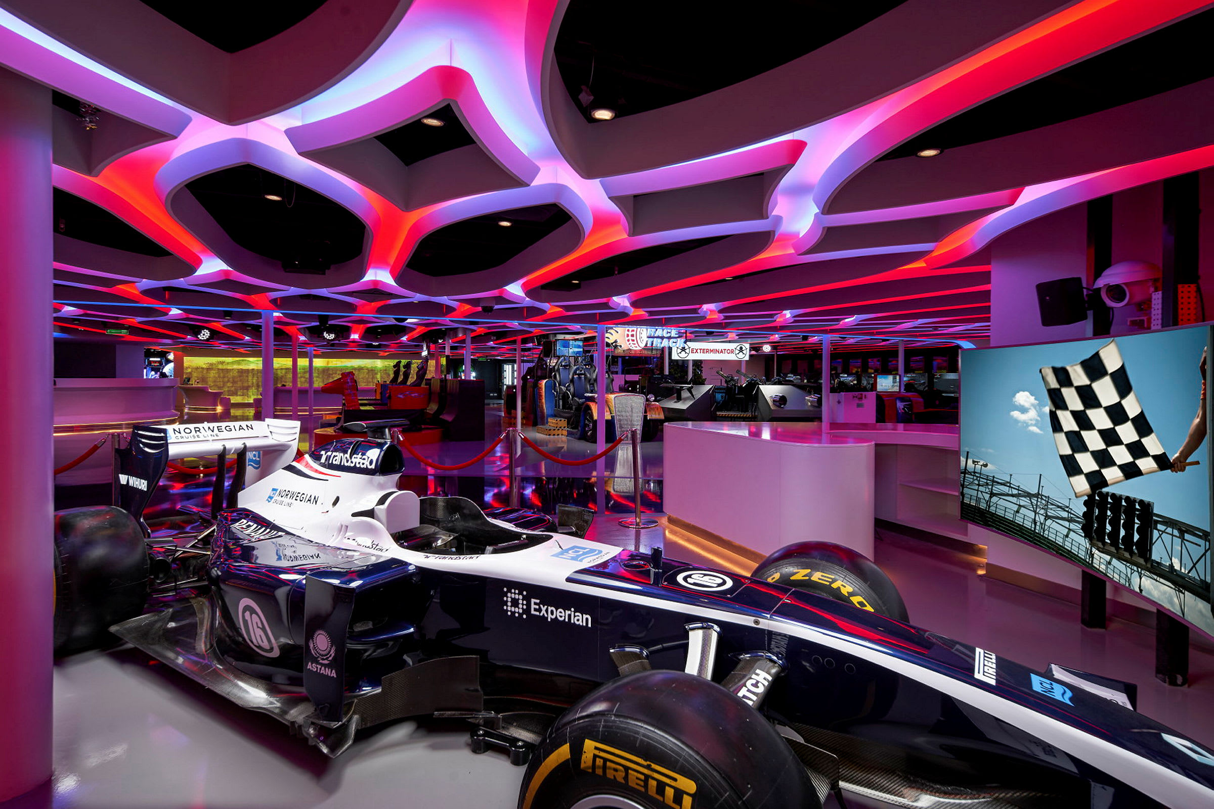 Formel 1-bil på en utstilling med neonlys opplyst tak. (AI-generert tekst)