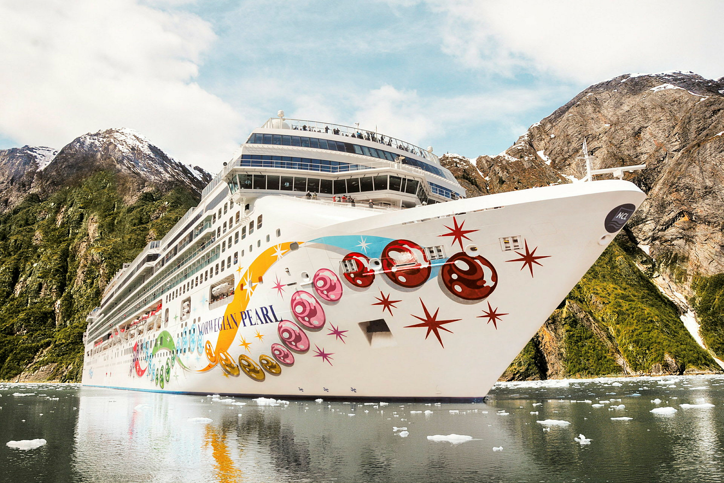 Cruiseskip i en fjord omgitt av fjell. (AI-generert tekst)