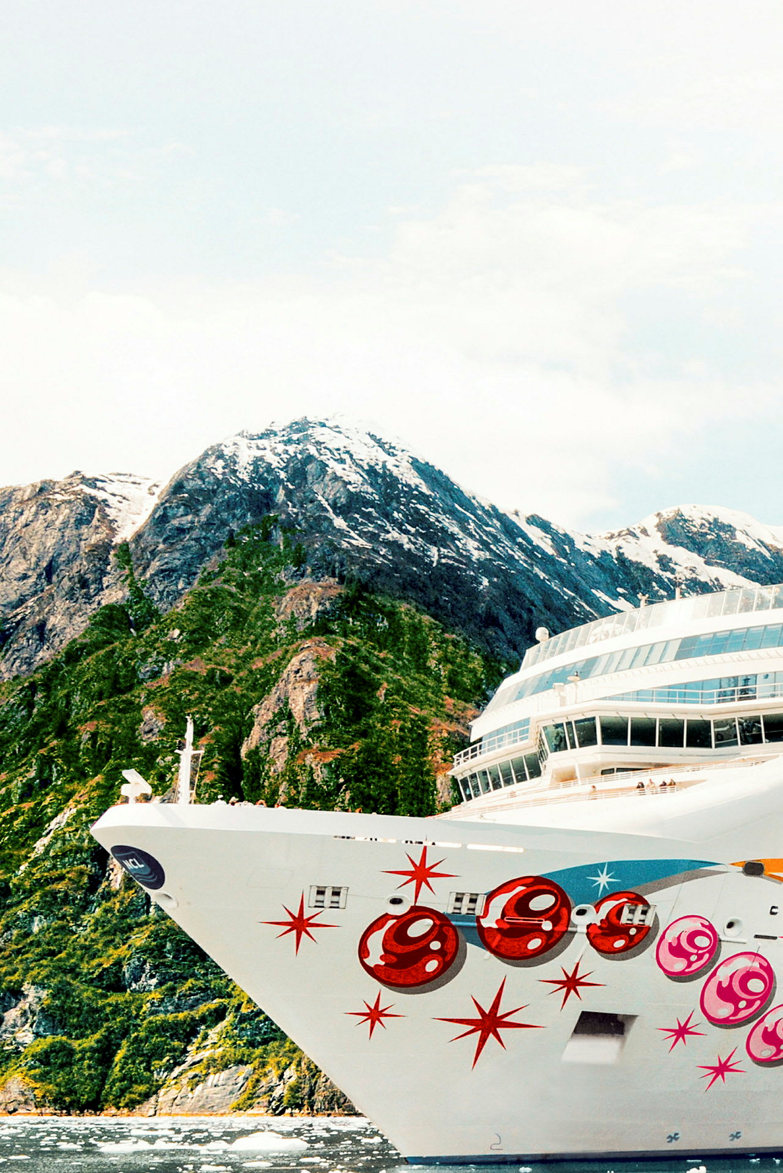 Et cruiseskip foran en fjellskråning med snø på toppen. (AI-generert tekst)