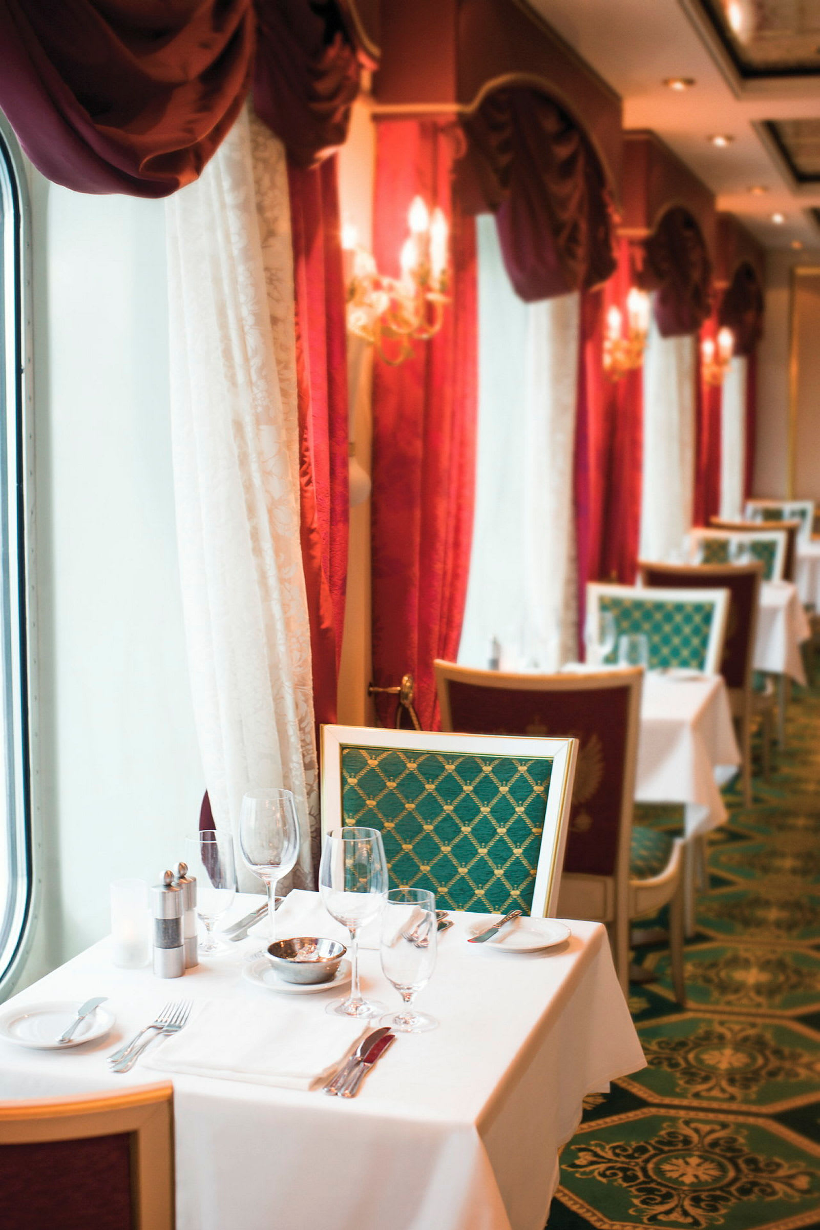 En elegant restaurant med dekkede bord og røde gardiner. (AI-generert tekst)