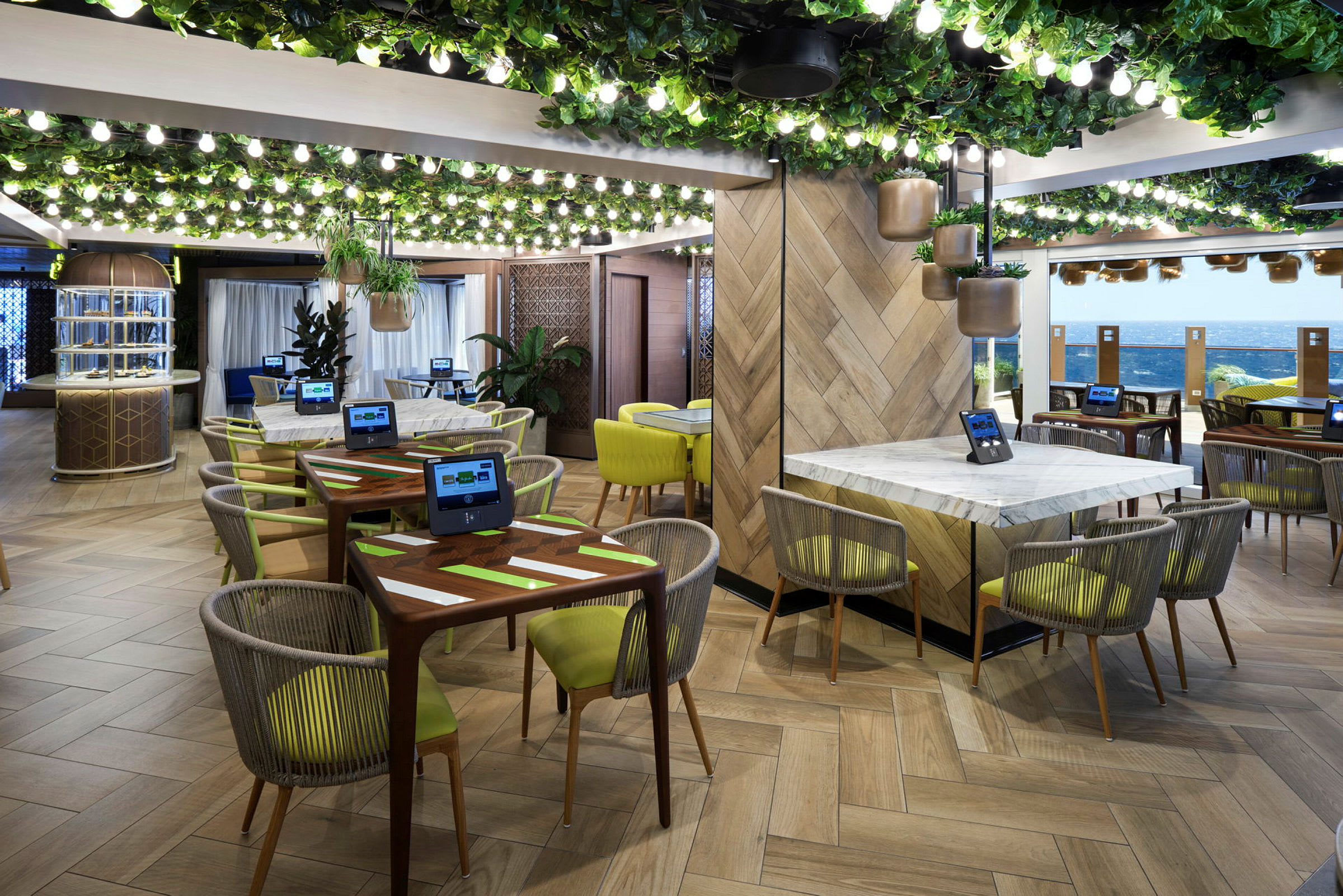 Restaurant med moderne innredning, grønne planter og bord med skjermer. (AI-generert tekst)