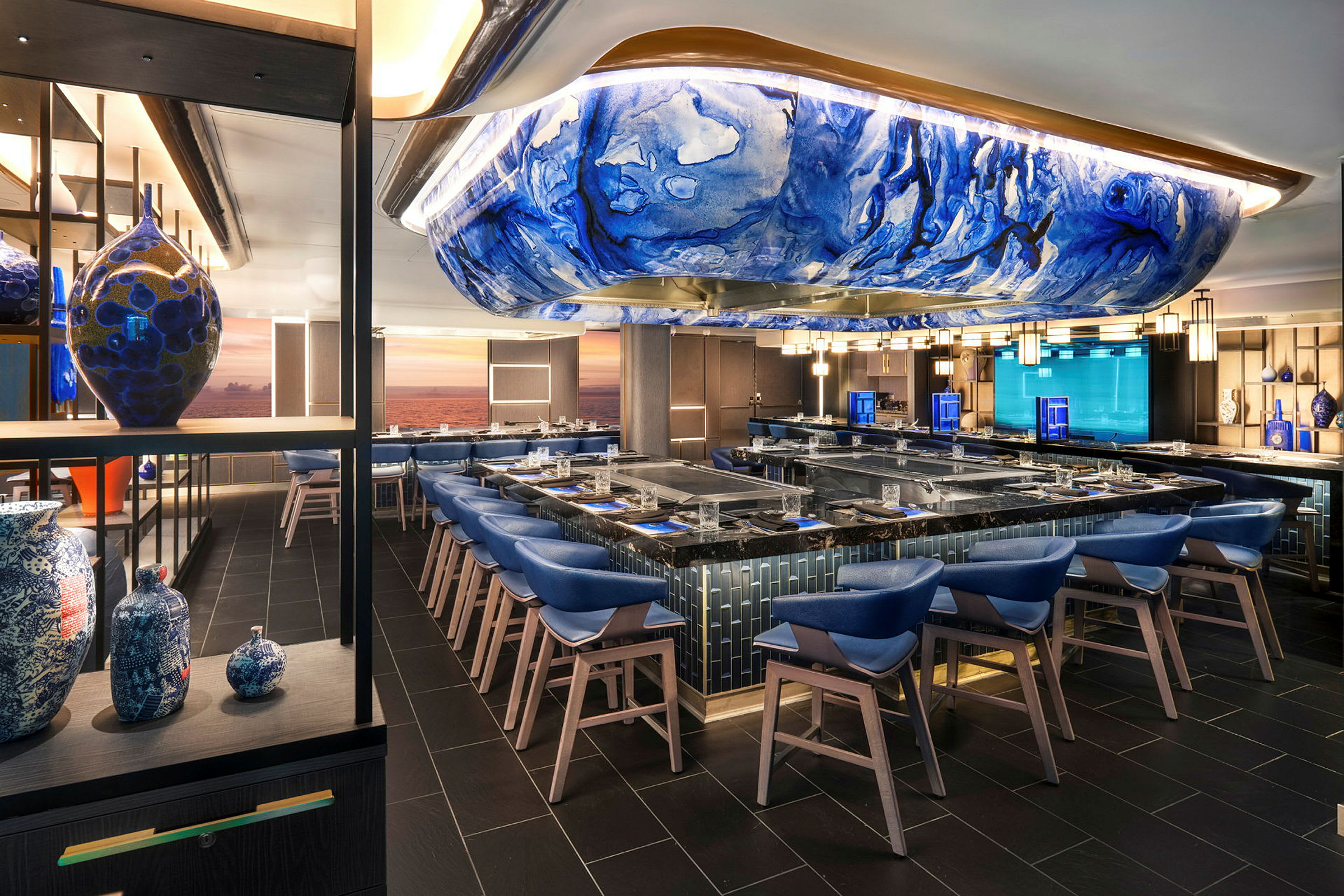Interiør av en moderne restaurant med blå stoler og et kunstnerisk blått tak. (AI-generert tekst)