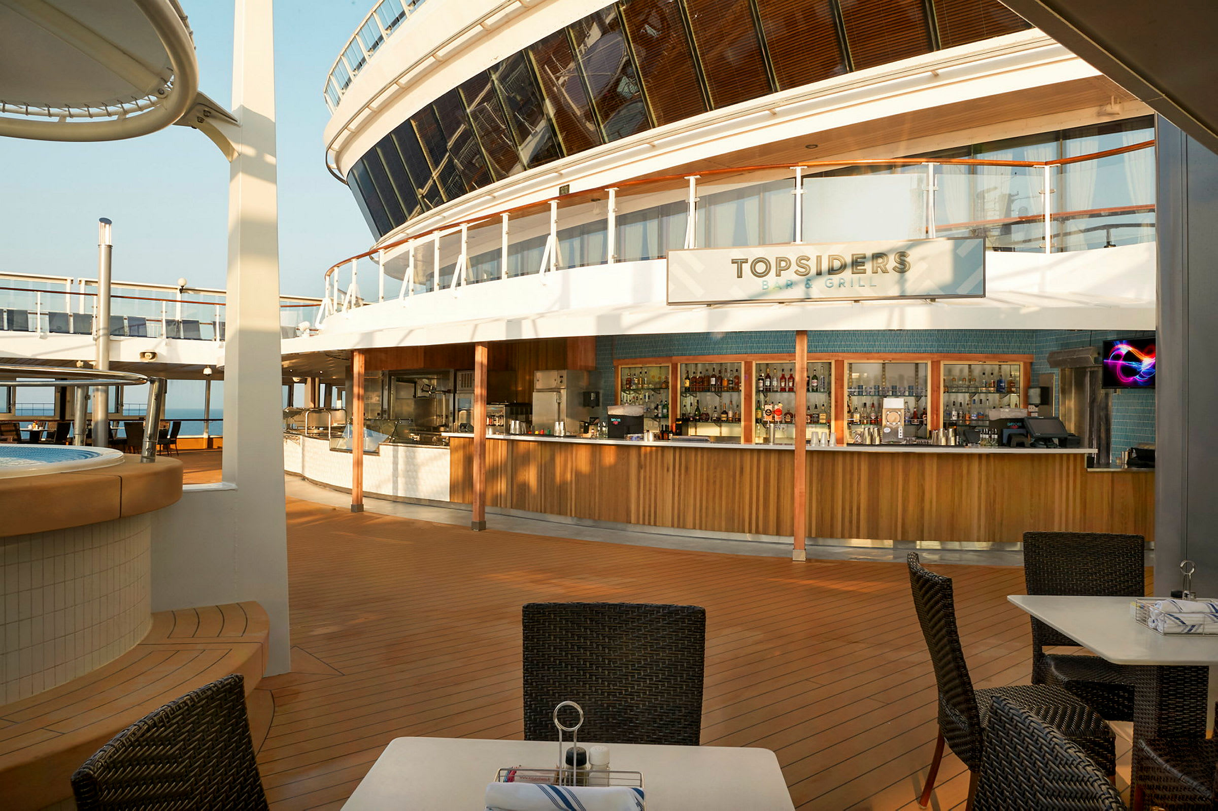 Utendørs serveringsområde på cruiseskip med bar og sitteplasser. (AI-generert tekst)