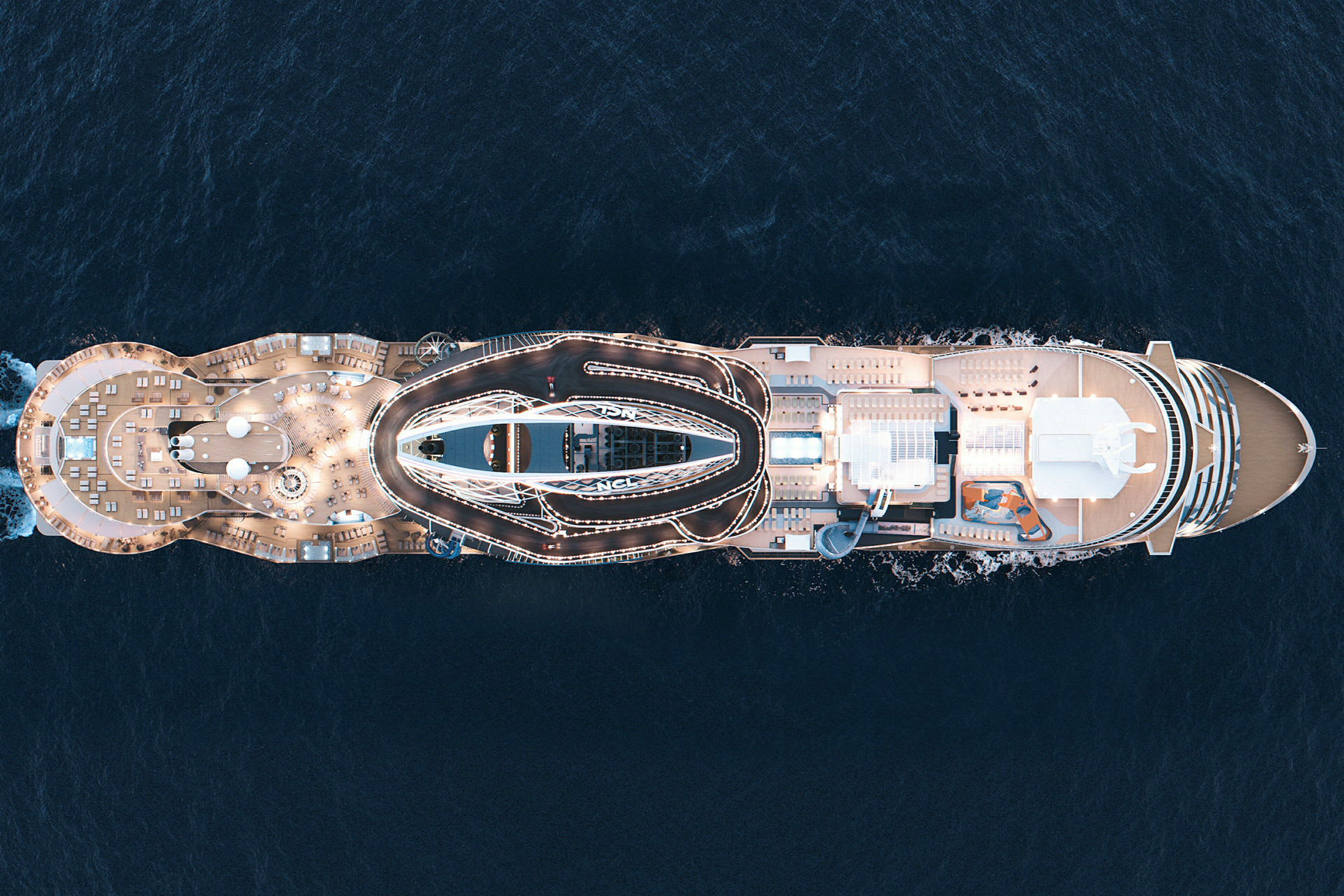 Bilde av et cruiseskip på havet, sett ovenfra med sterkt opplyste dekk og dekorasjoner. (AI-generert tekst)