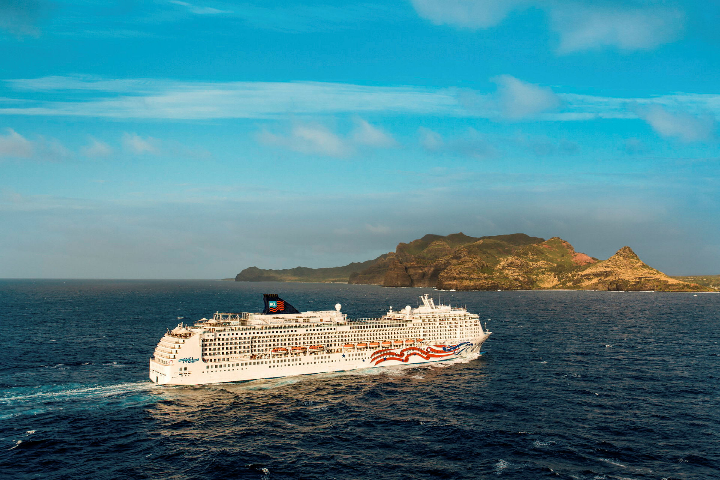Et cruiseskip seiler på åpent hav med en øy i bakgrunnen. (AI-generert tekst)